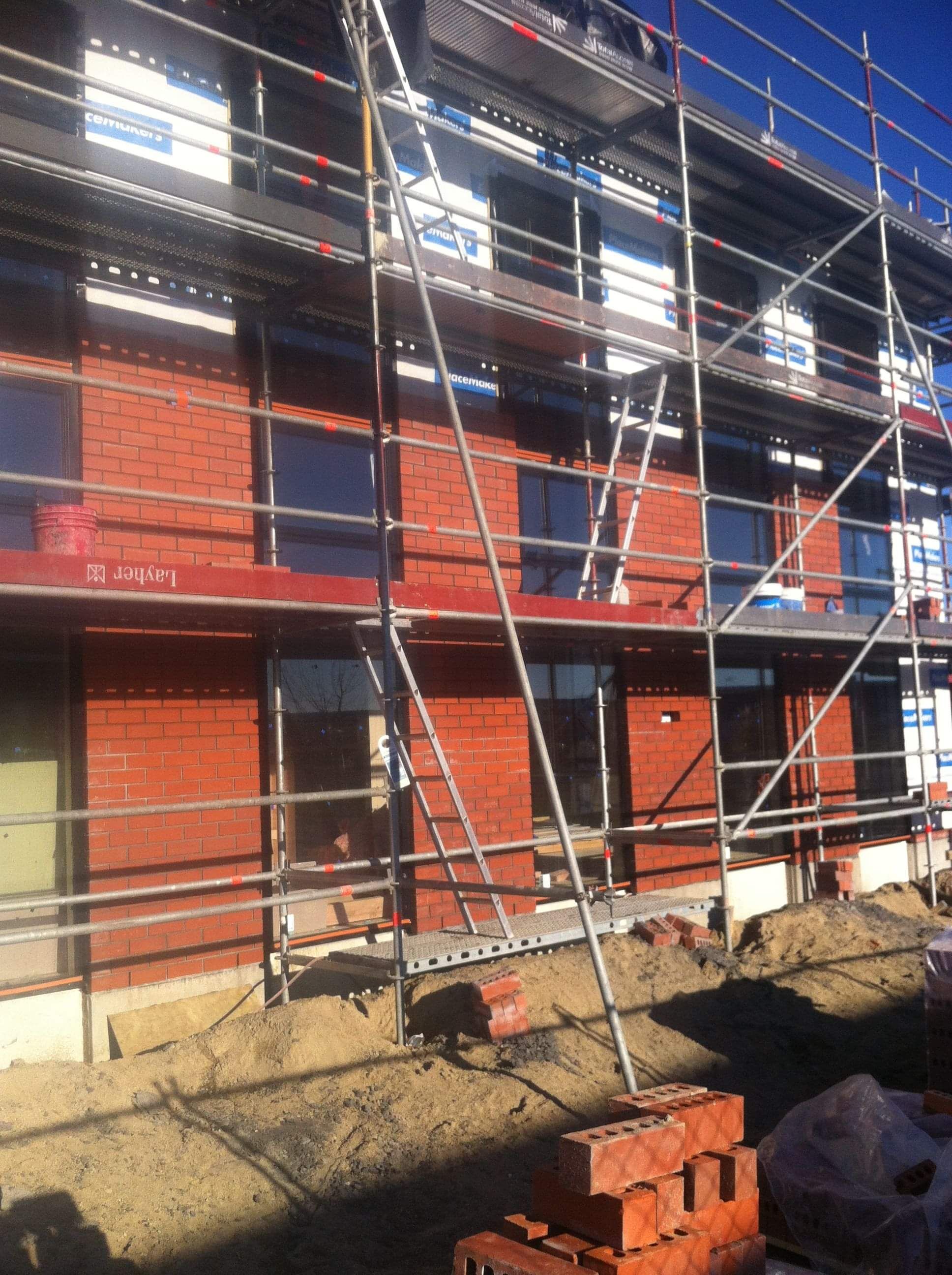 Modern waiting room with blue couch, round coffee table with plant, white vase, and painting on the wall.