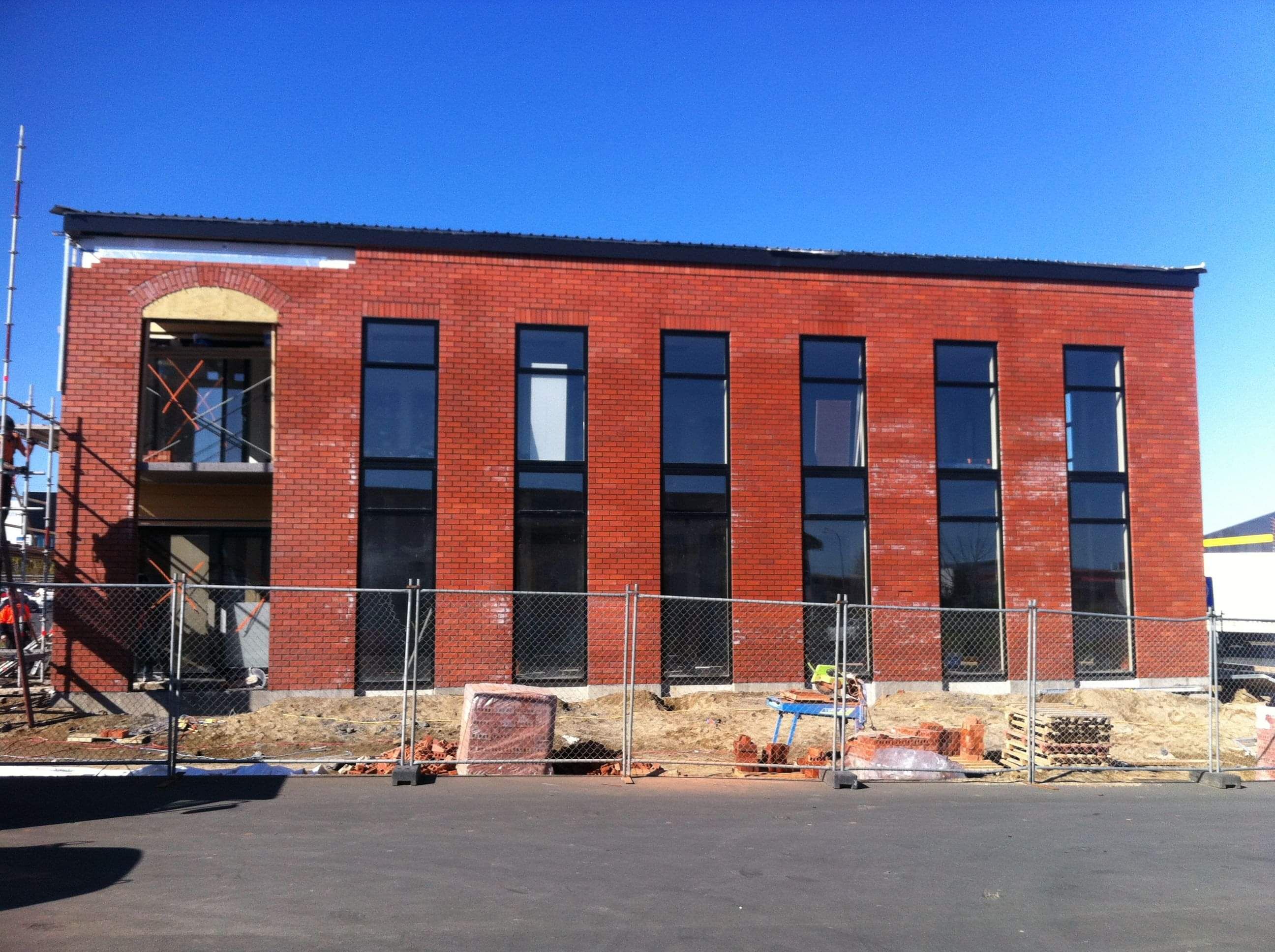 Modern waiting room with blue couch, round coffee table with plant, white vase, and painting on the wall.