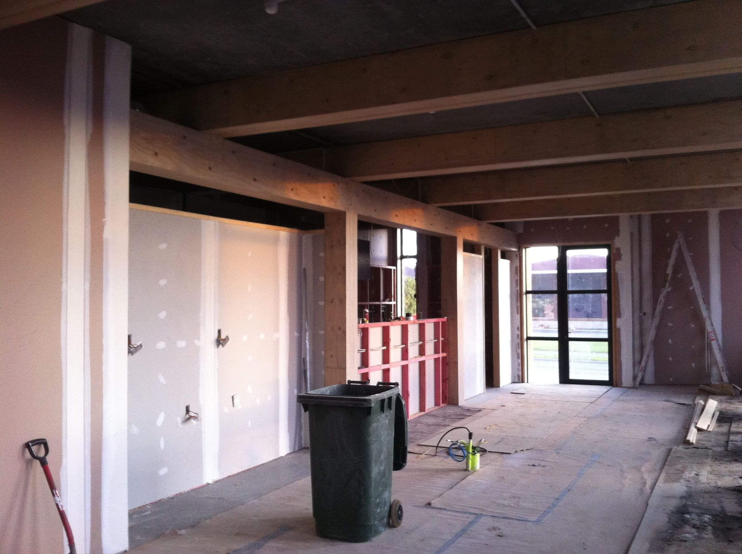 Modern waiting room with blue couch, round coffee table with plant, white vase, and painting on the wall.