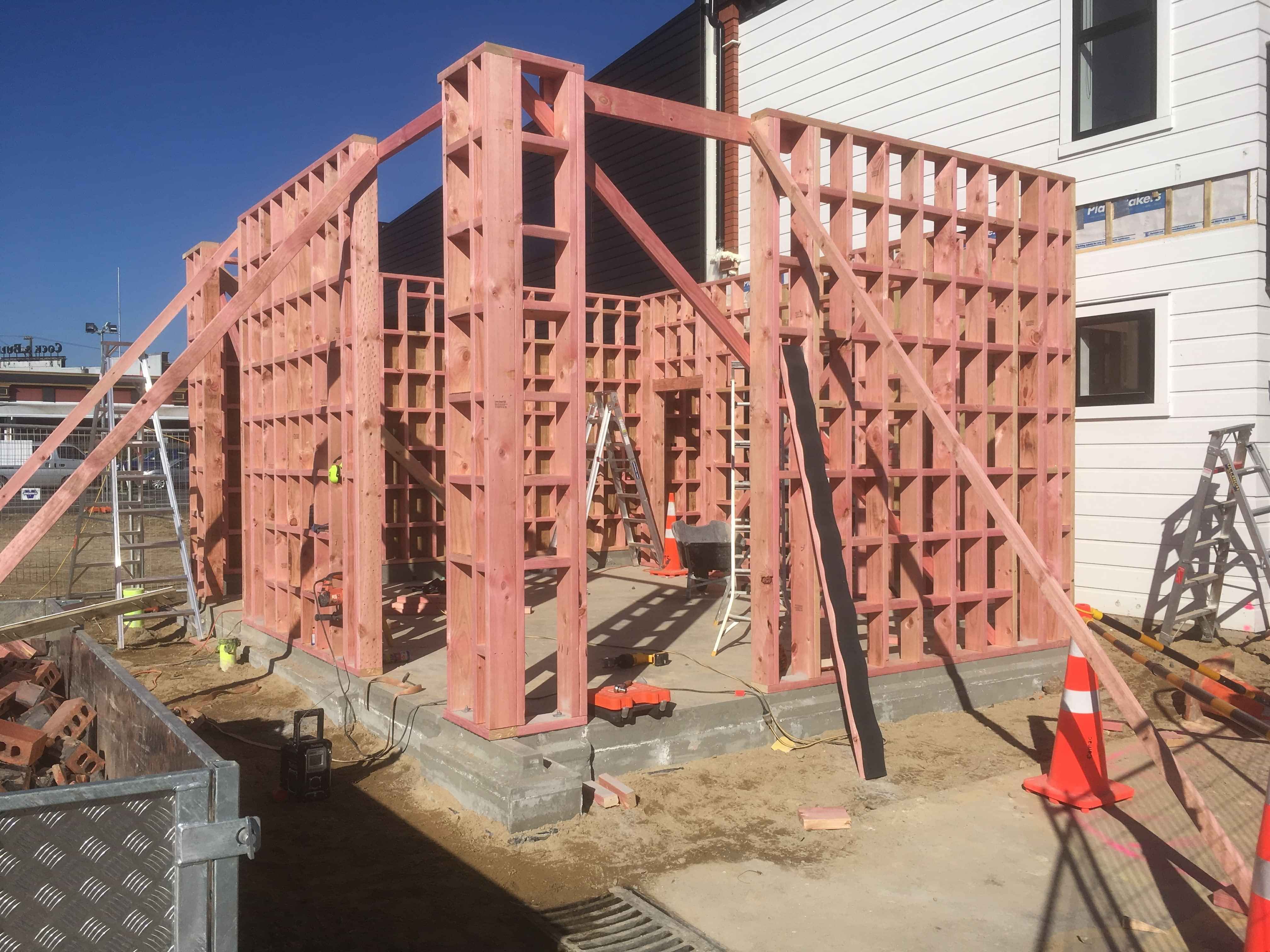 Modern waiting room with blue couch, round coffee table with plant, white vase, and painting on the wall.