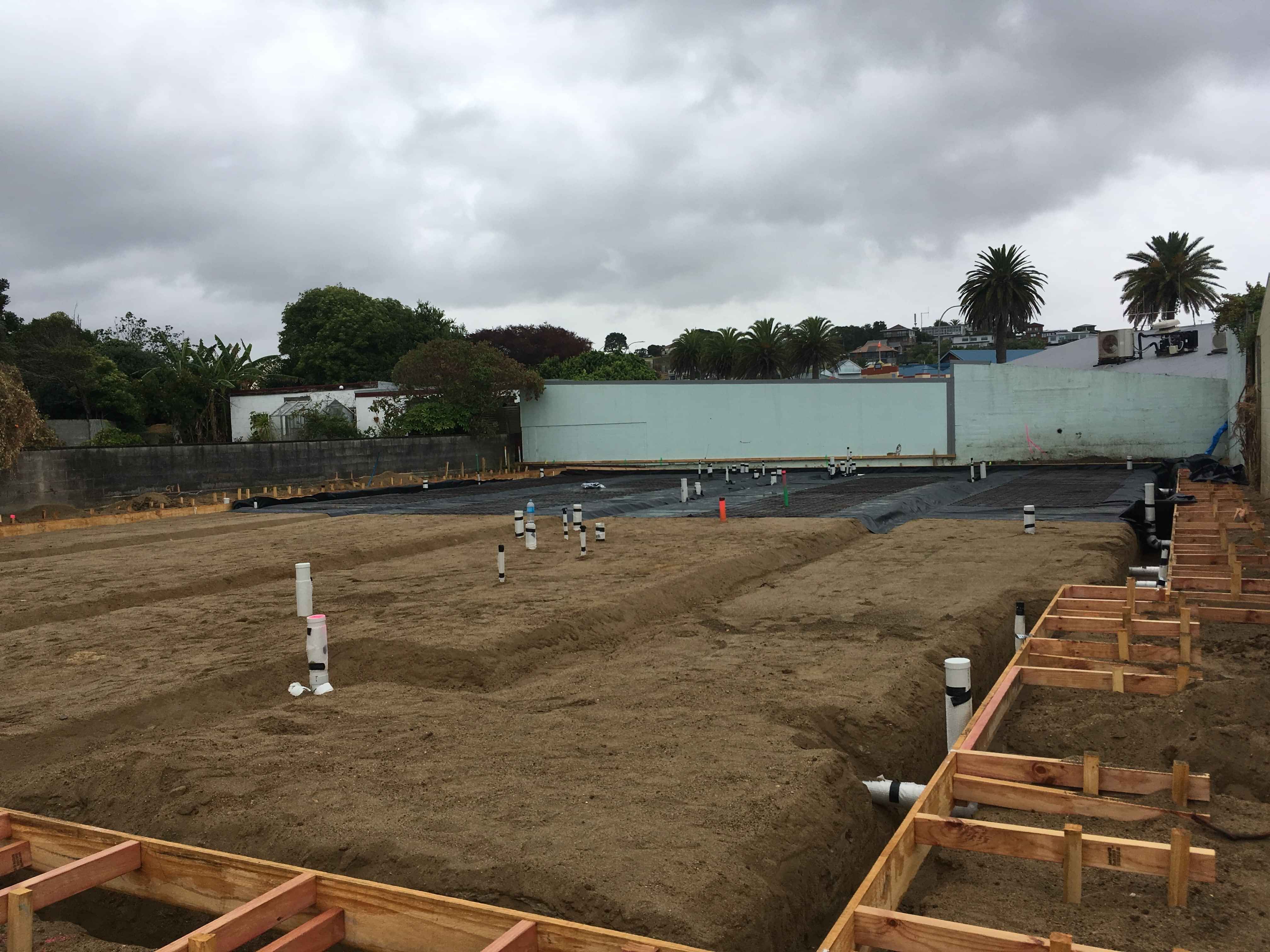 Modern waiting room with blue couch, round coffee table with plant, white vase, and painting on the wall.