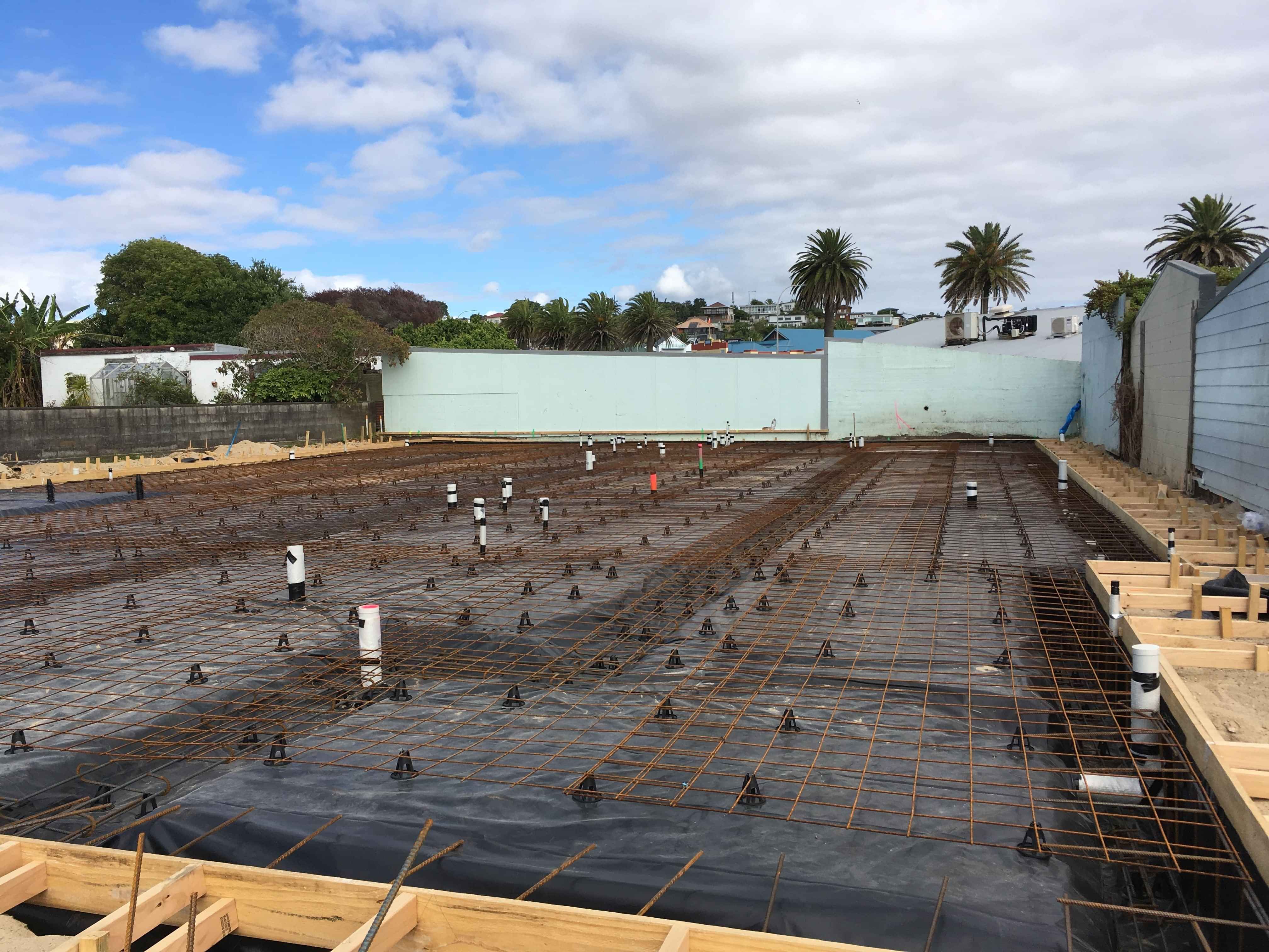 Modern waiting room with blue couch, round coffee table with plant, white vase, and painting on the wall.