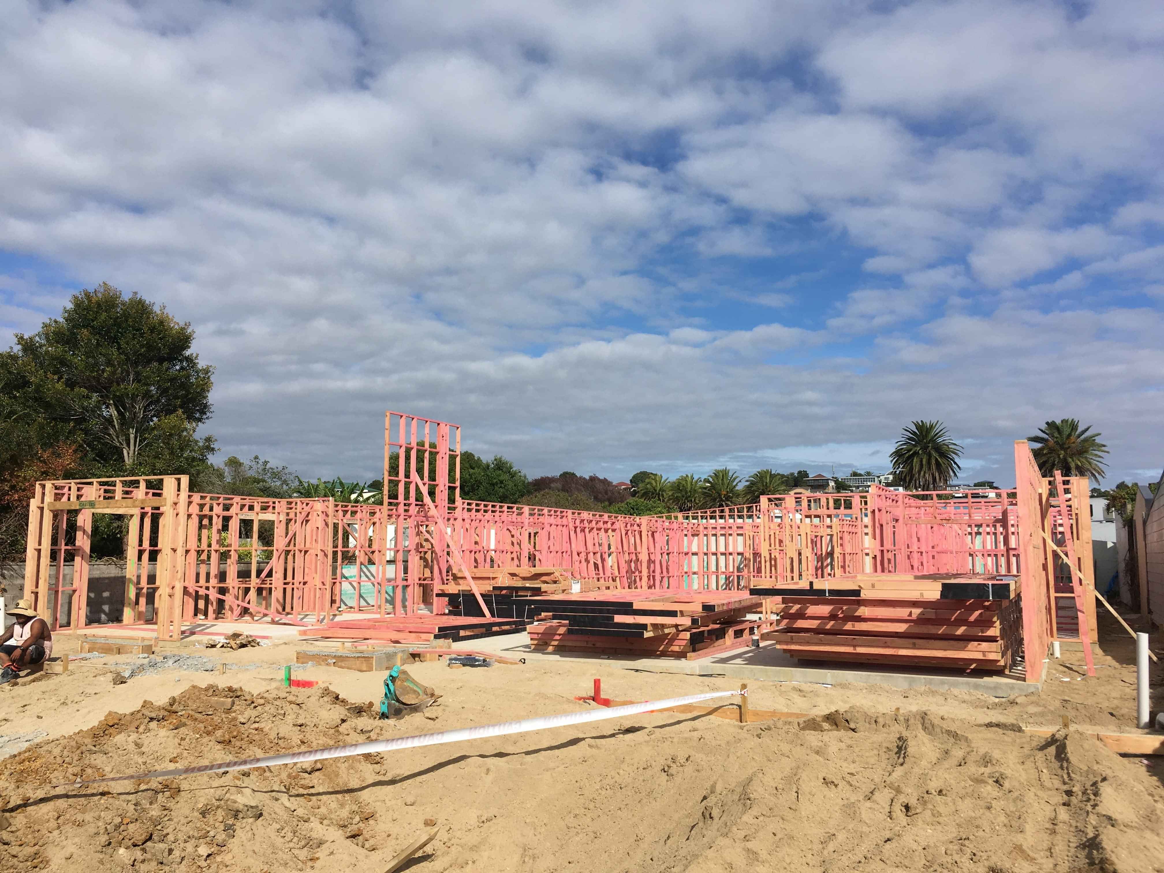 Modern waiting room with blue couch, round coffee table with plant, white vase, and painting on the wall.