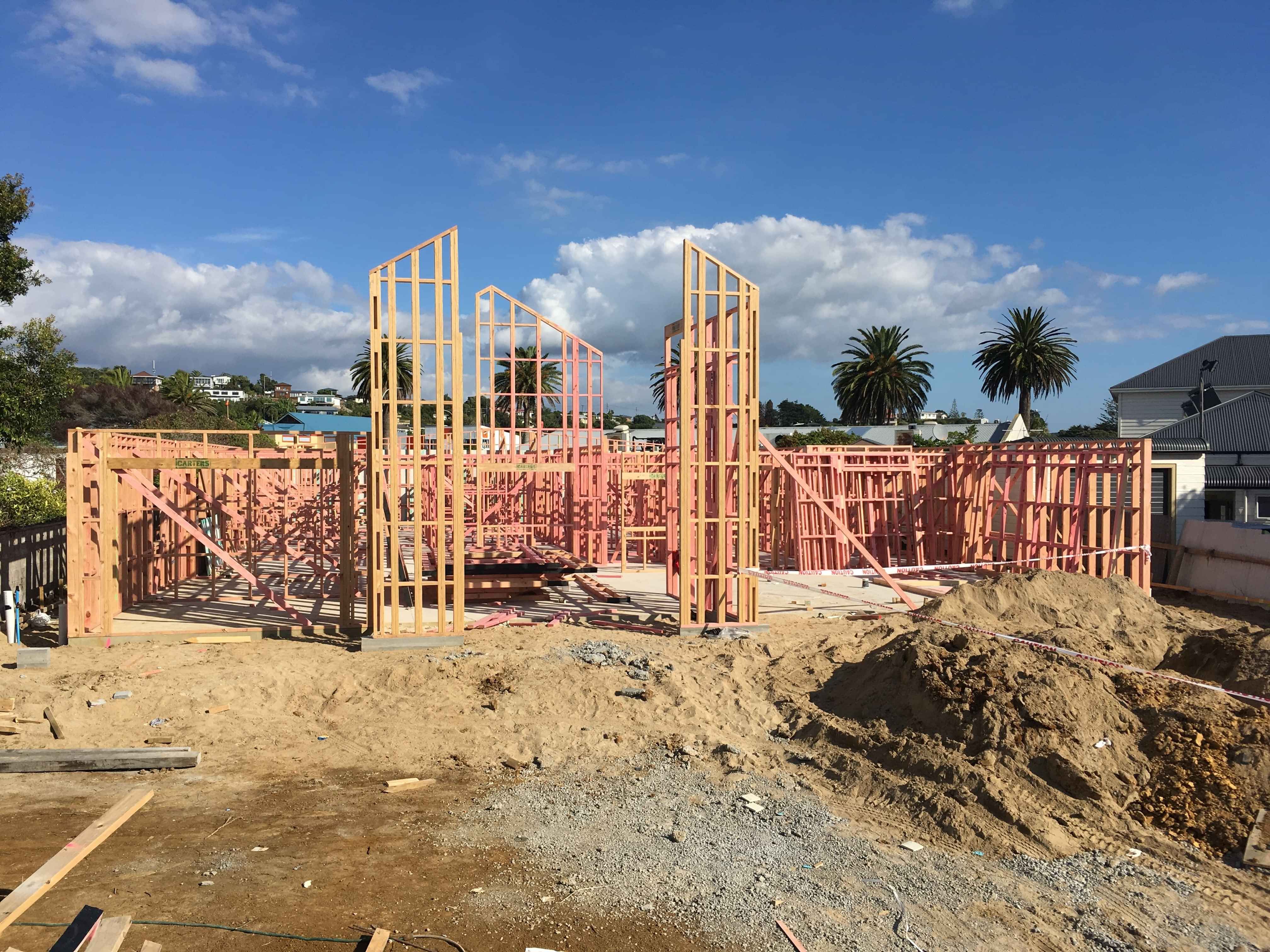 Modern waiting room with blue couch, round coffee table with plant, white vase, and painting on the wall.