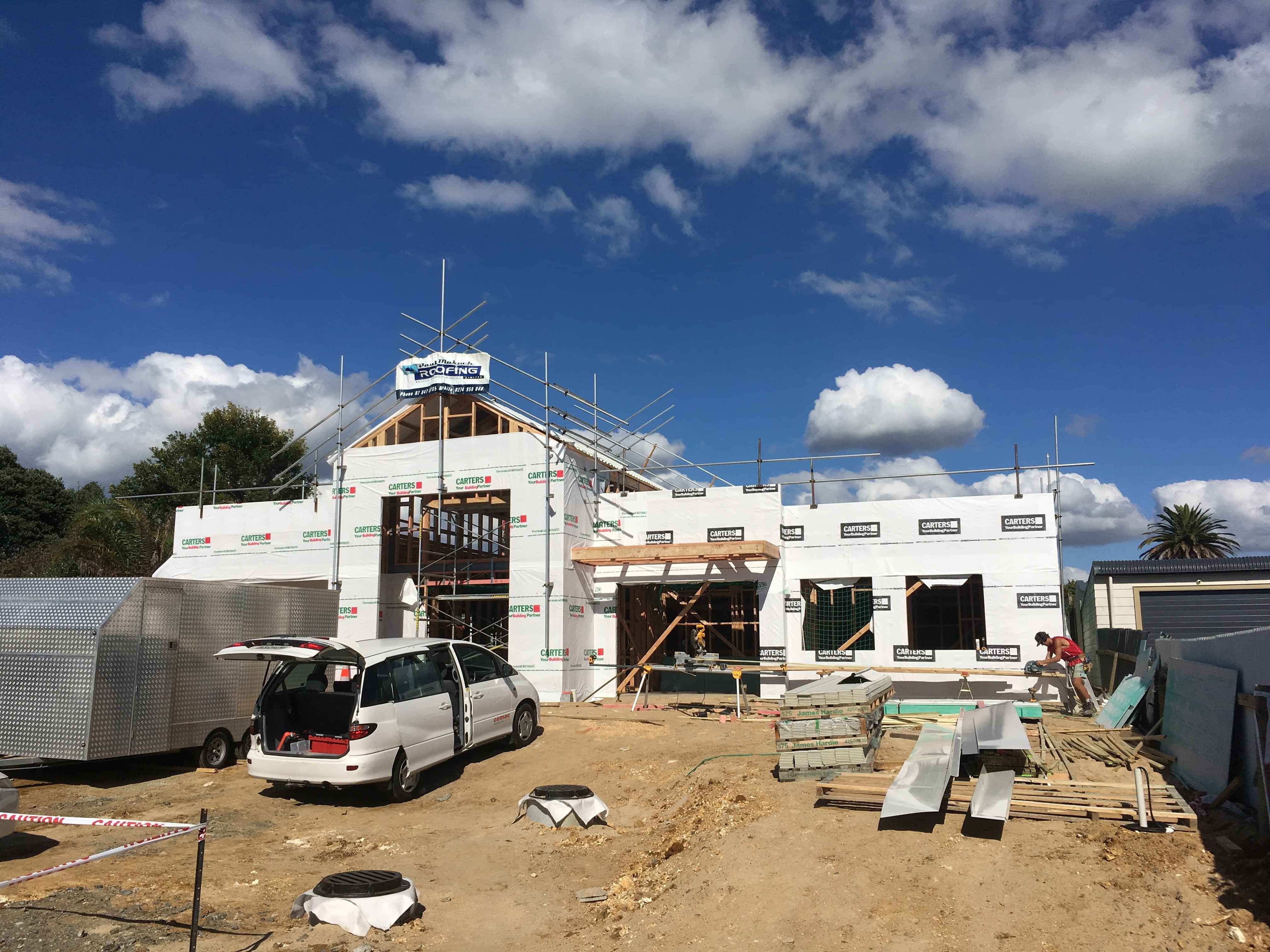 Modern waiting room with blue couch, round coffee table with plant, white vase, and painting on the wall.