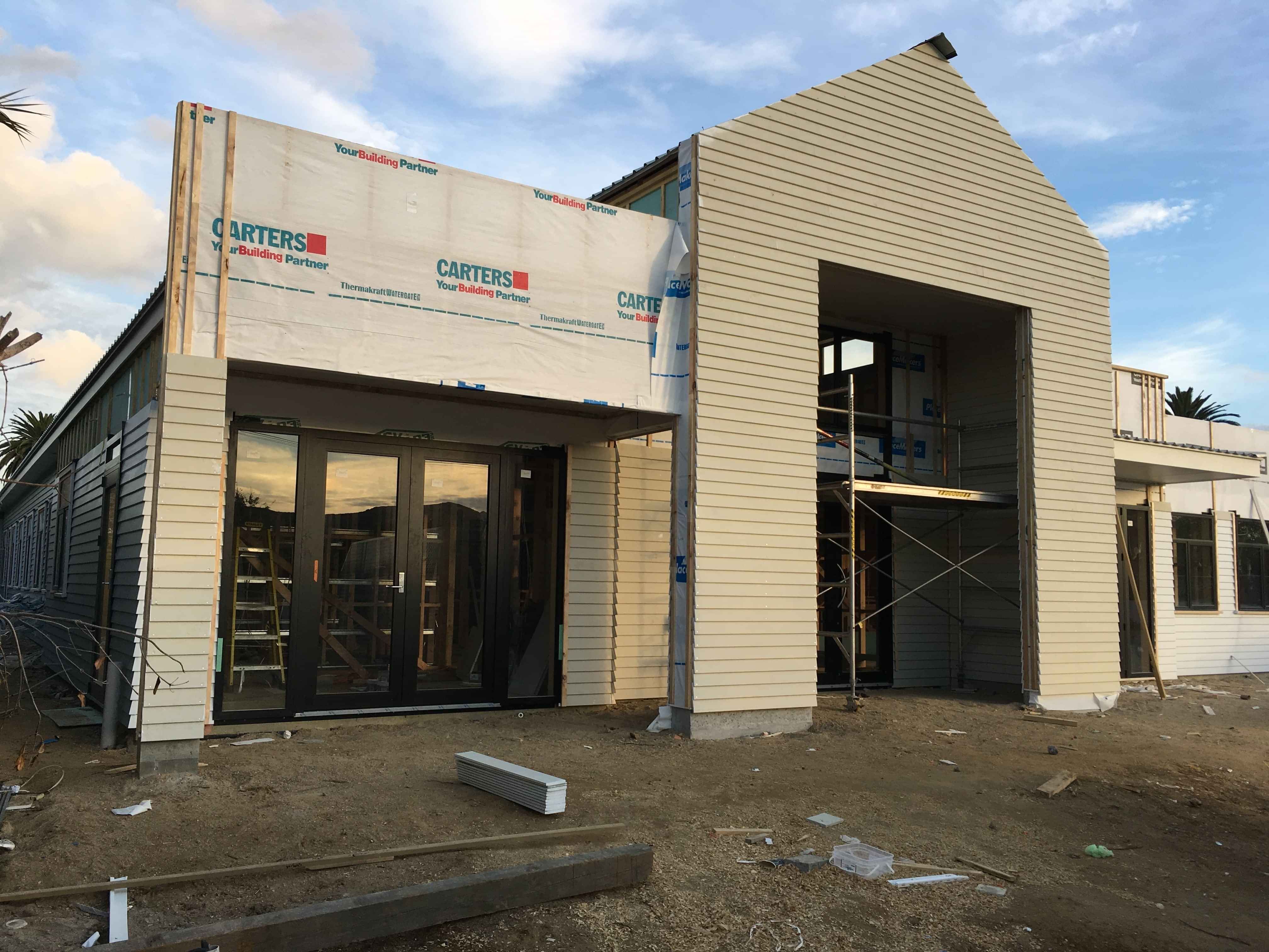 Modern waiting room with blue couch, round coffee table with plant, white vase, and painting on the wall.