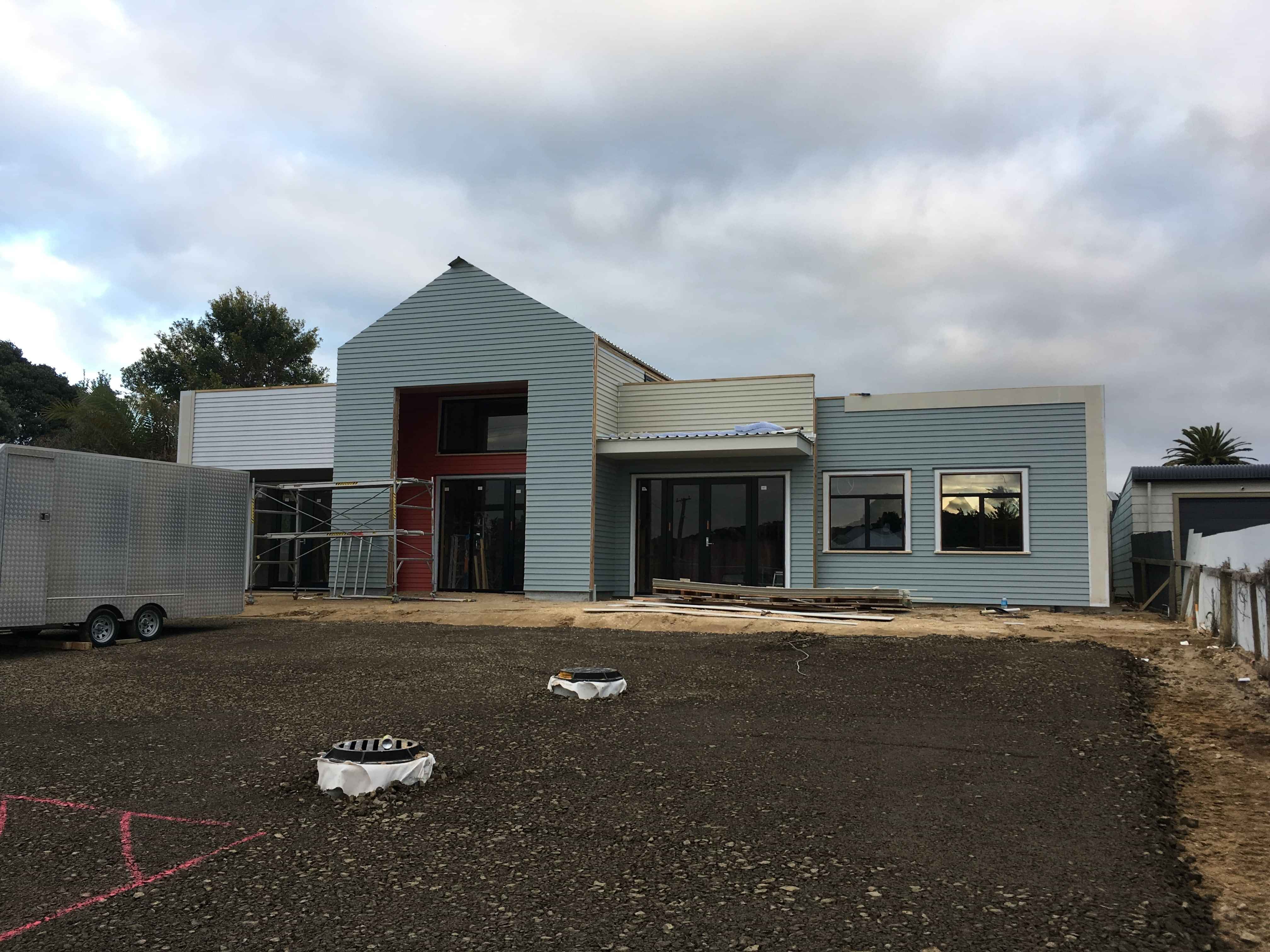 Modern waiting room with blue couch, round coffee table with plant, white vase, and painting on the wall.