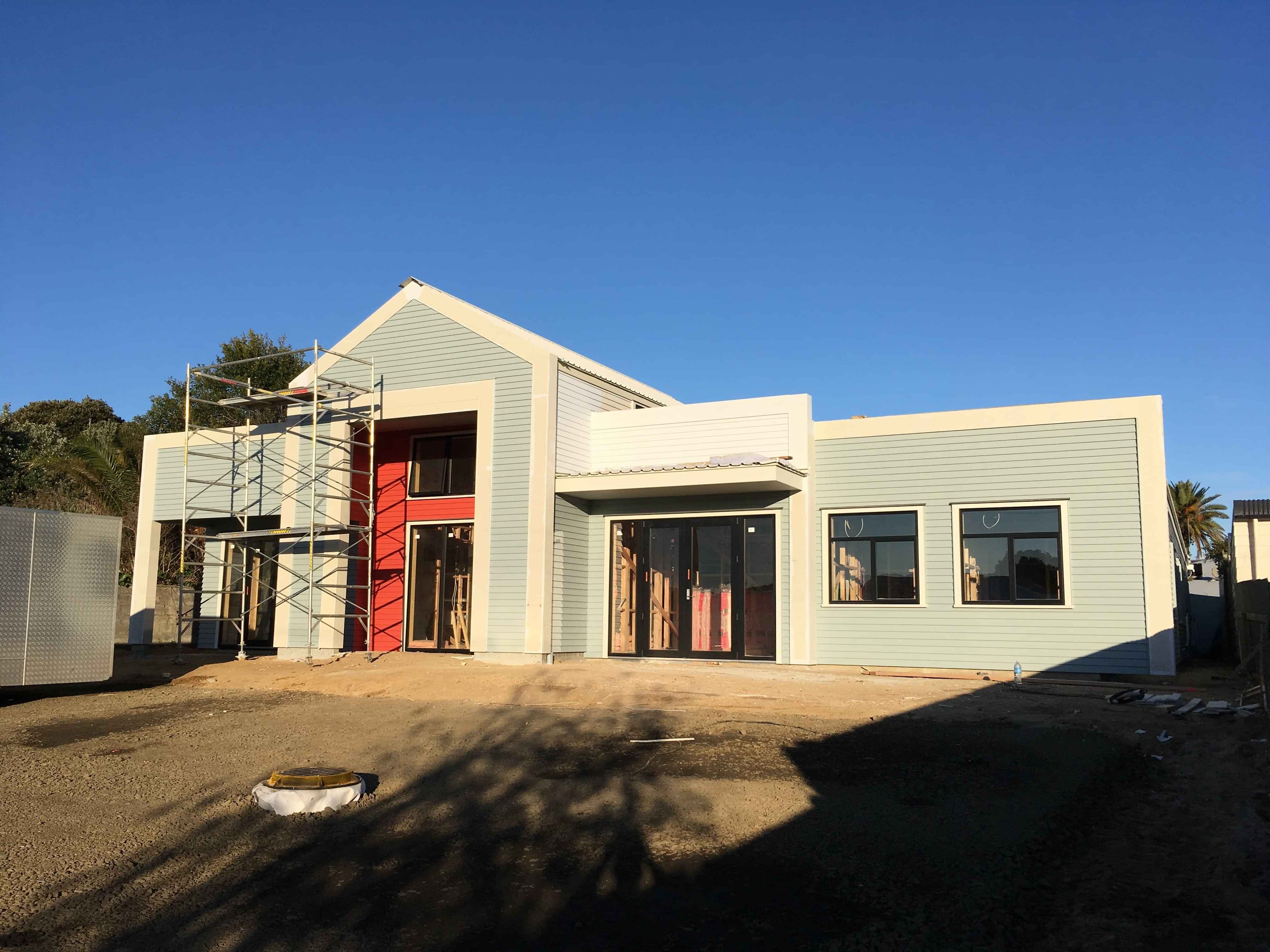 Modern waiting room with blue couch, round coffee table with plant, white vase, and painting on the wall.