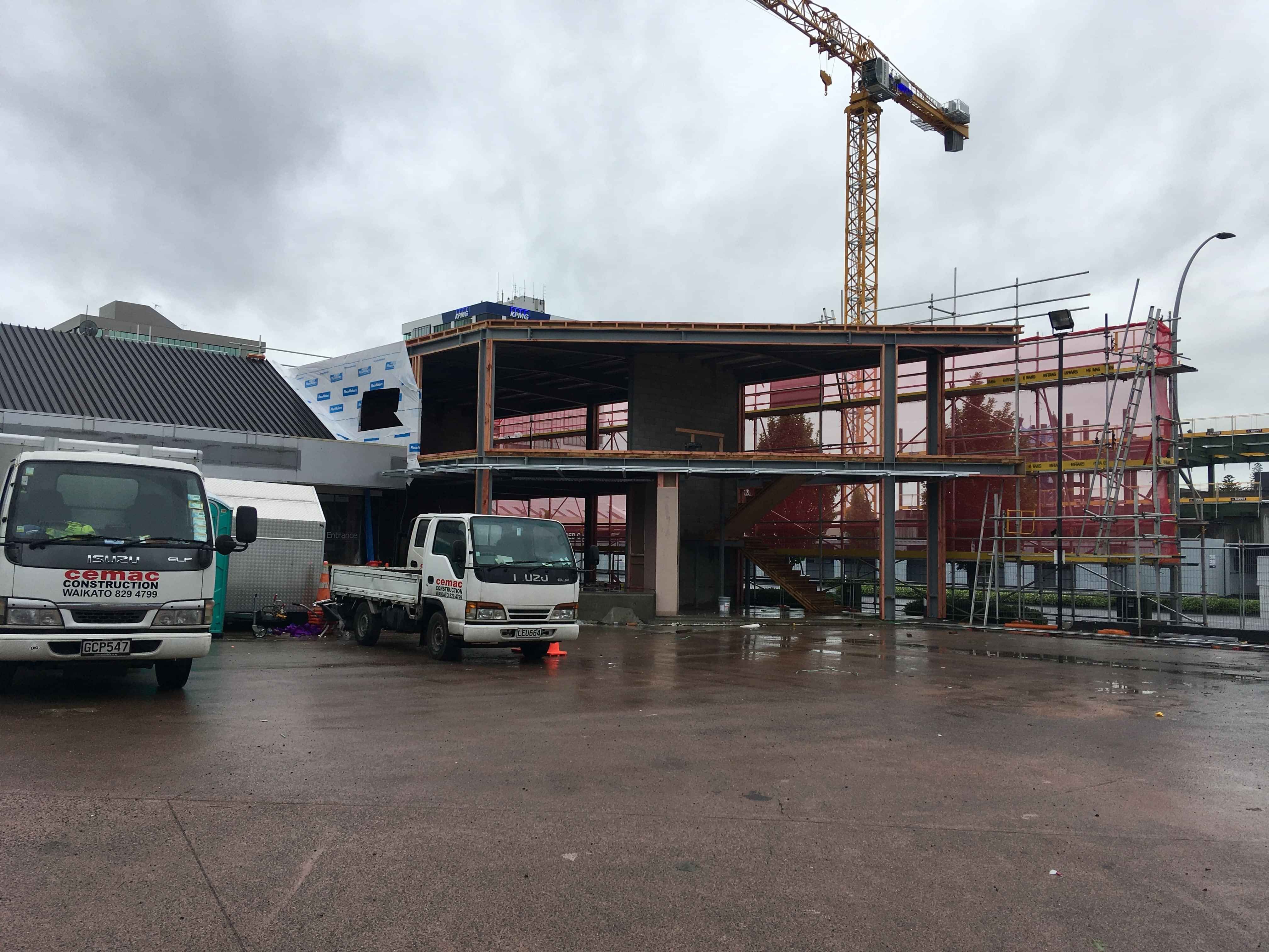 Modern waiting room with blue couch, round coffee table with plant, white vase, and painting on the wall.