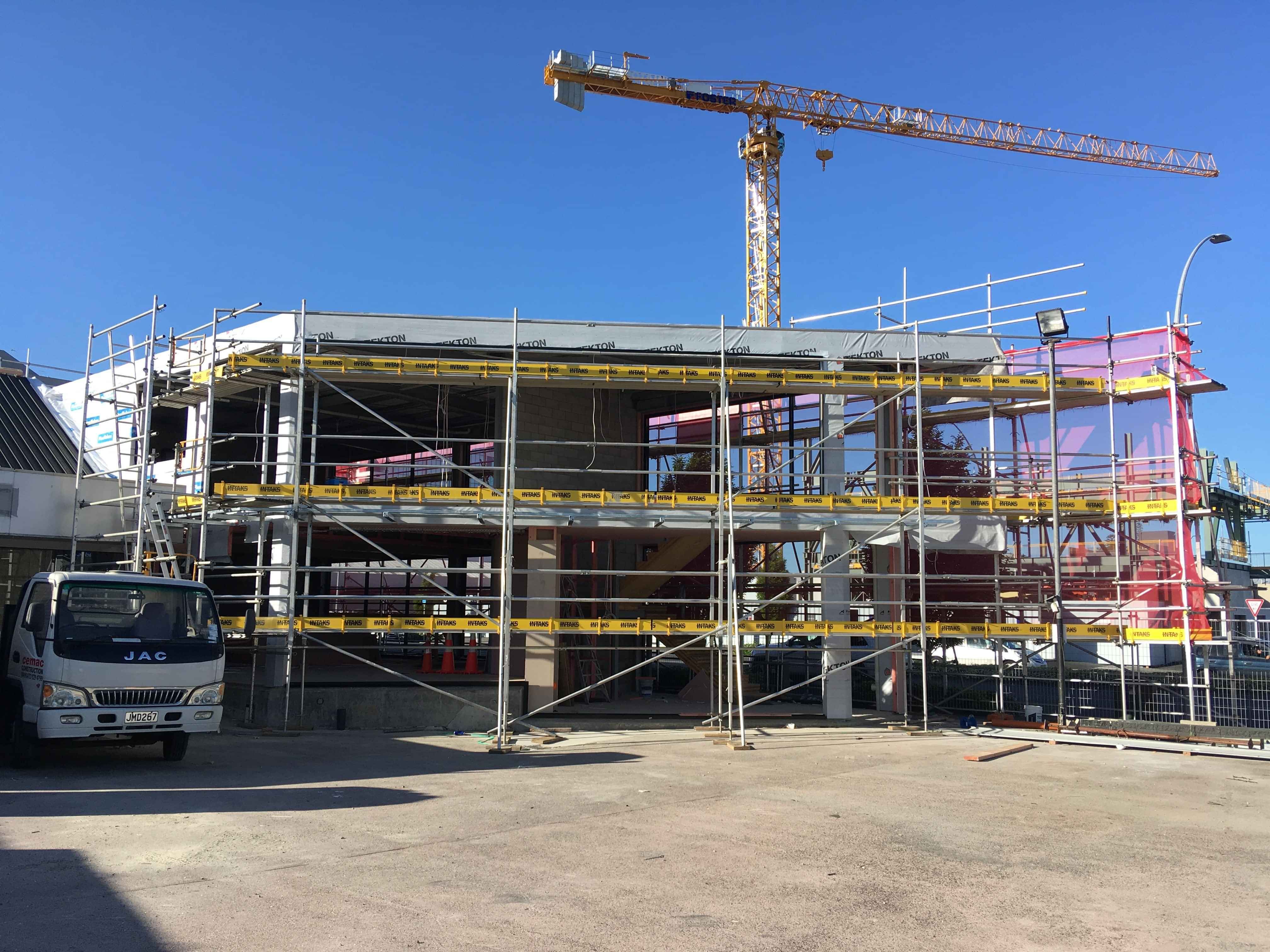 Modern waiting room with blue couch, round coffee table with plant, white vase, and painting on the wall.