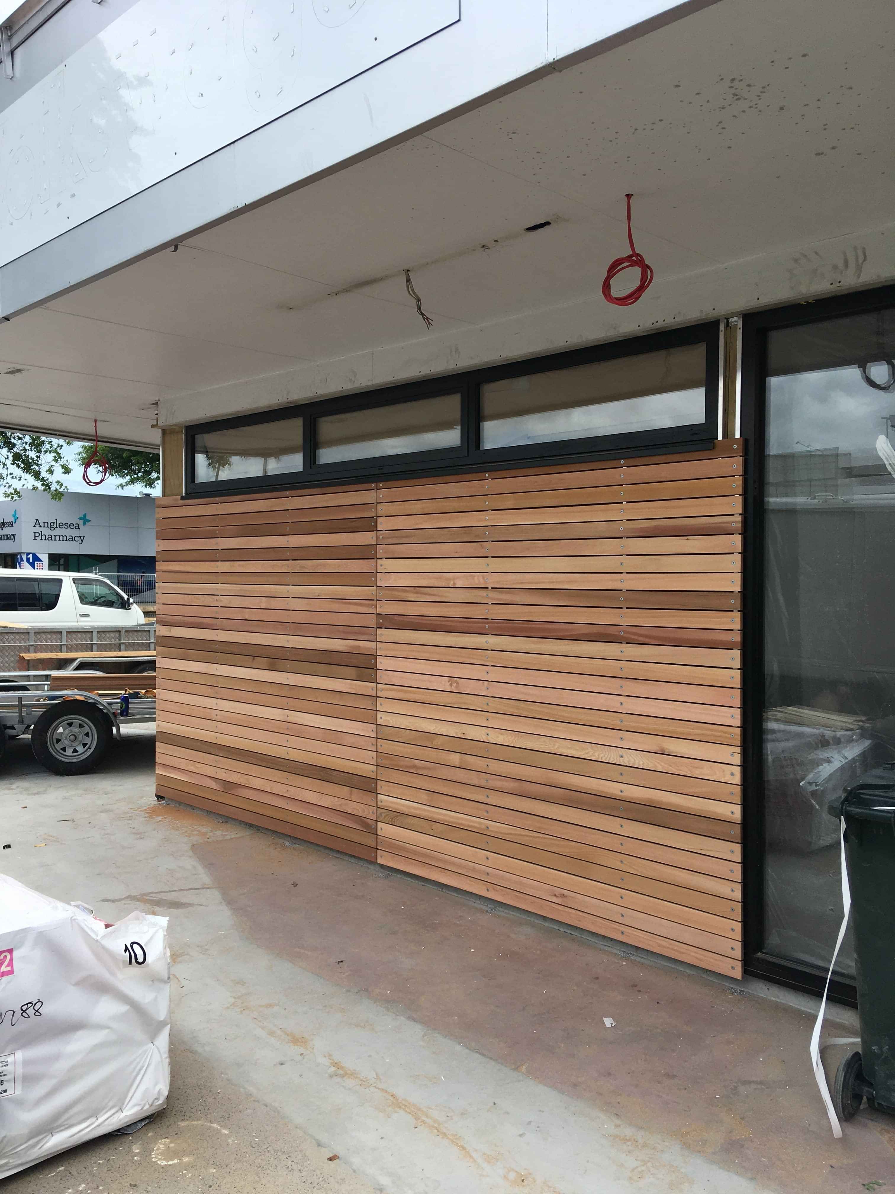 Modern waiting room with blue couch, round coffee table with plant, white vase, and painting on the wall.