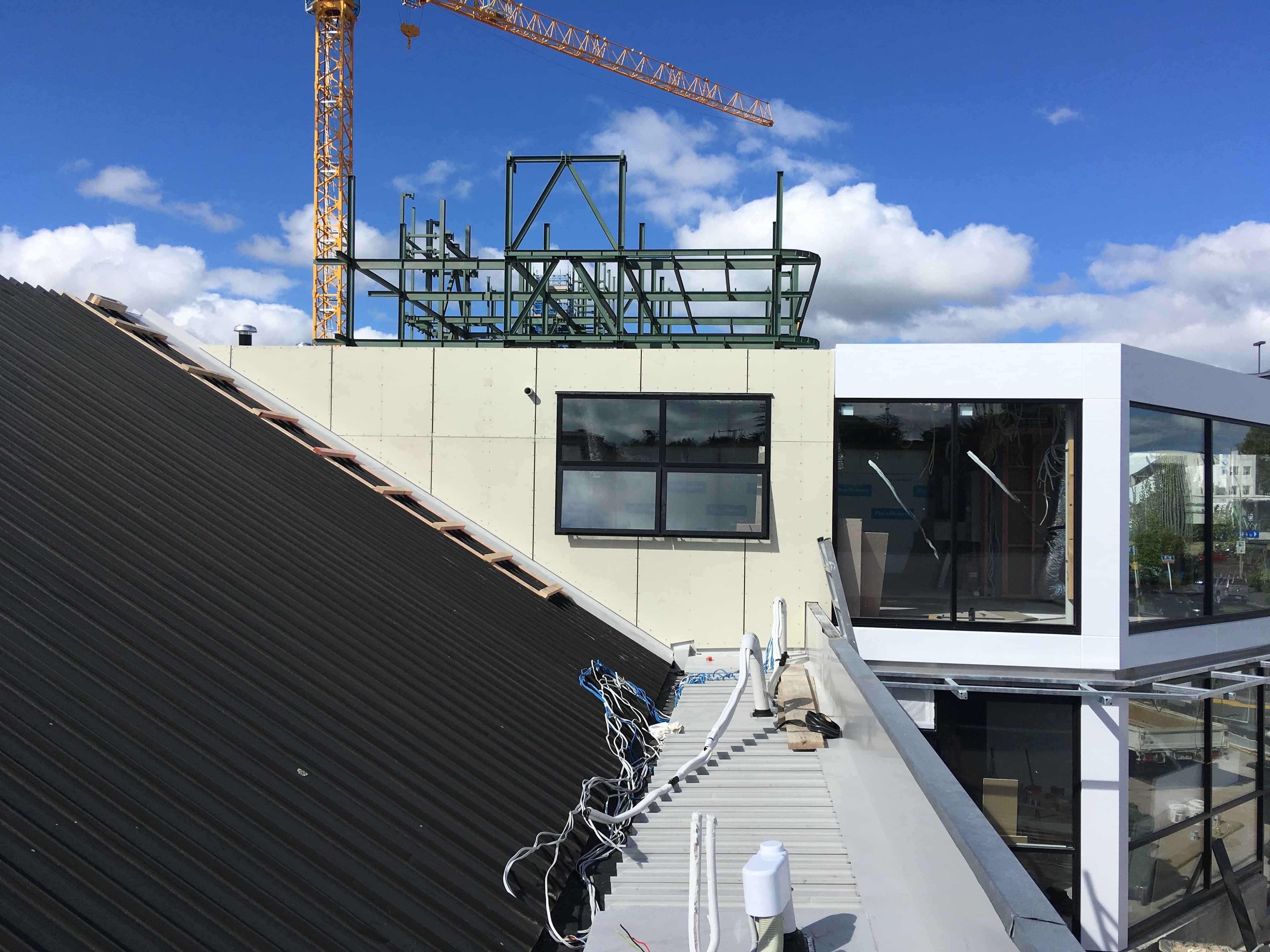 Modern waiting room with blue couch, round coffee table with plant, white vase, and painting on the wall.
