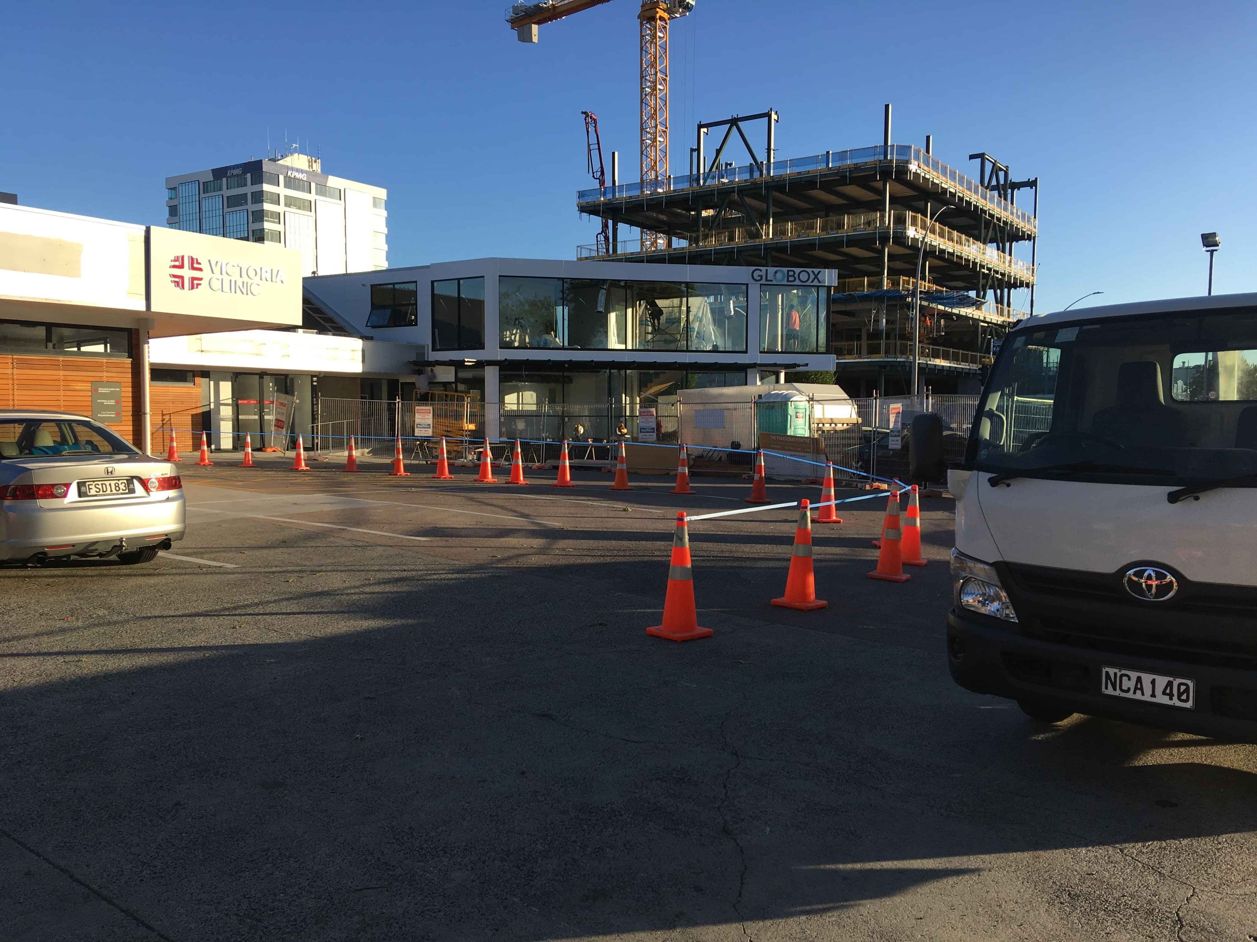 Modern waiting room with blue couch, round coffee table with plant, white vase, and painting on the wall.