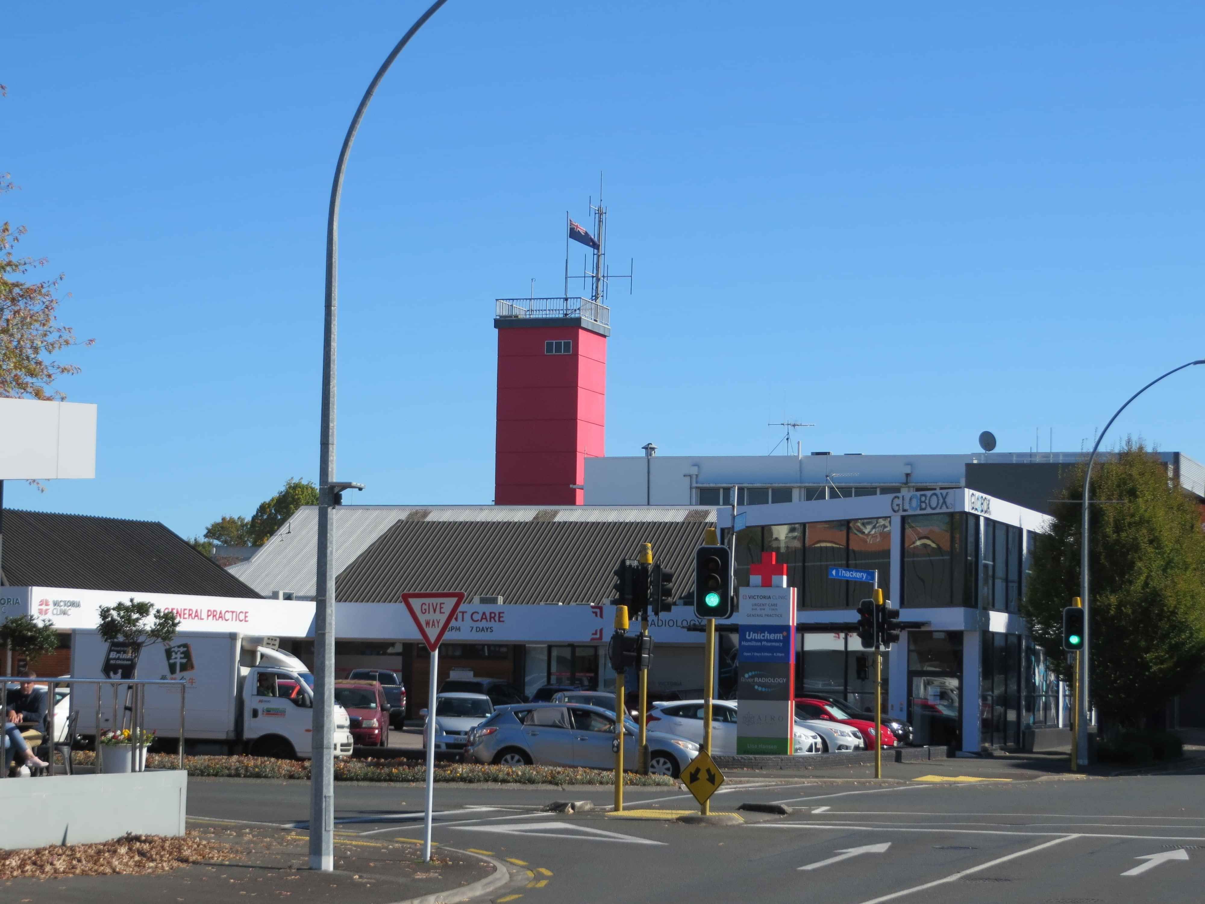 Modern waiting room with blue couch, round coffee table with plant, white vase, and painting on the wall.
