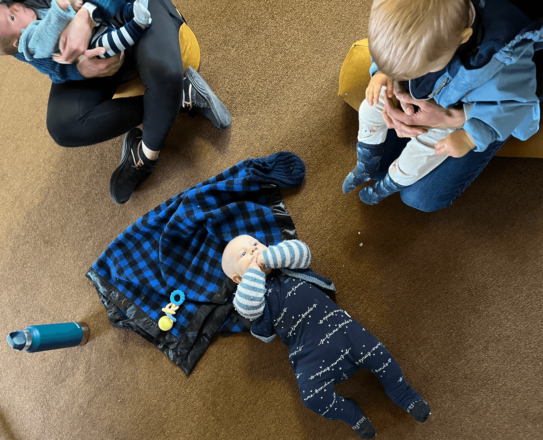 Beautiful Beginnings Māmā & Me Circles - Mums sat chatting around a baby in blue lying on the floor