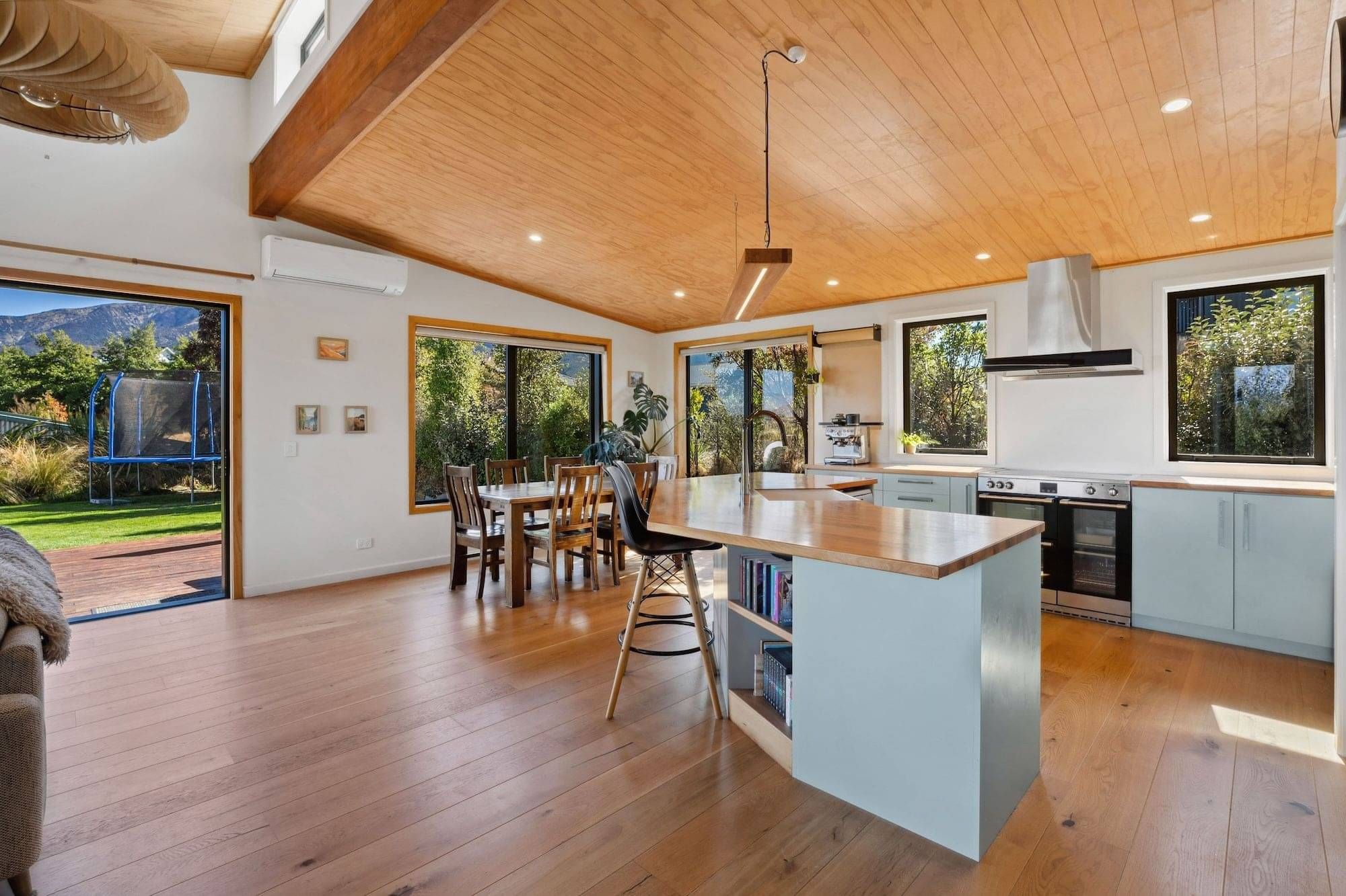A kitchen built by Steve with green-grey cupboard fronts and a heirloom timber totara benchtop.