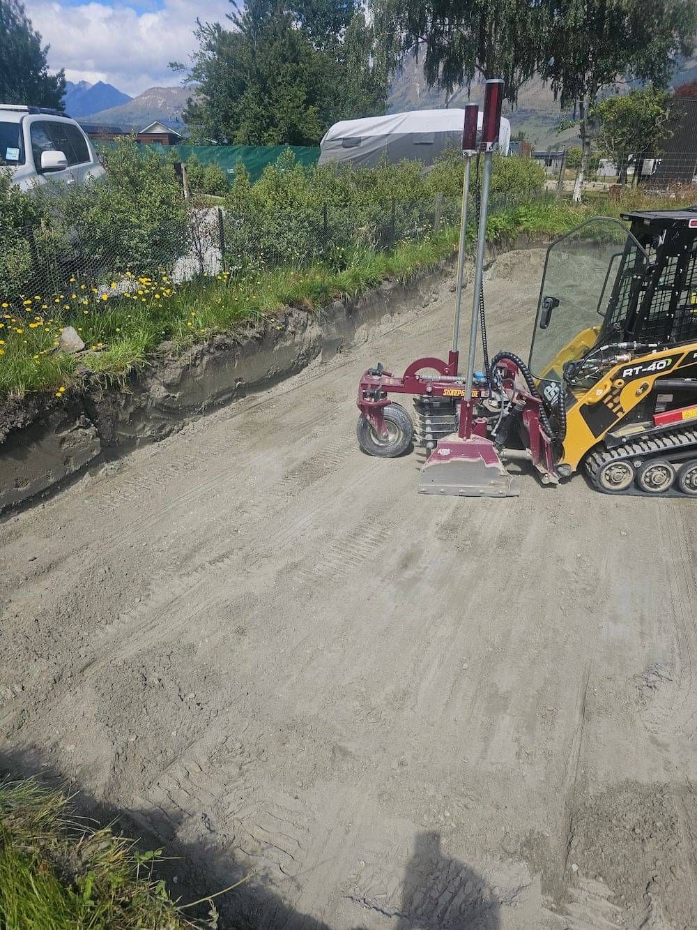 A skid steer levelling and preparing a site platform ready for foundations in Queenstown, NZ.