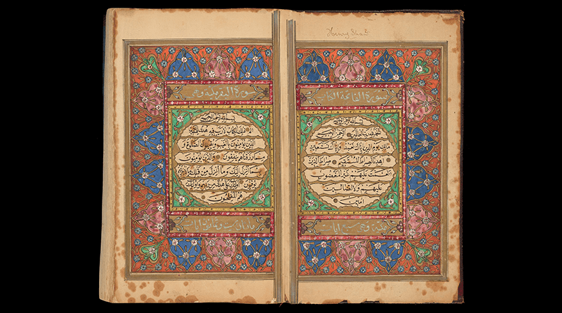 Book of the Qur'an is open, showing two decorated pages.