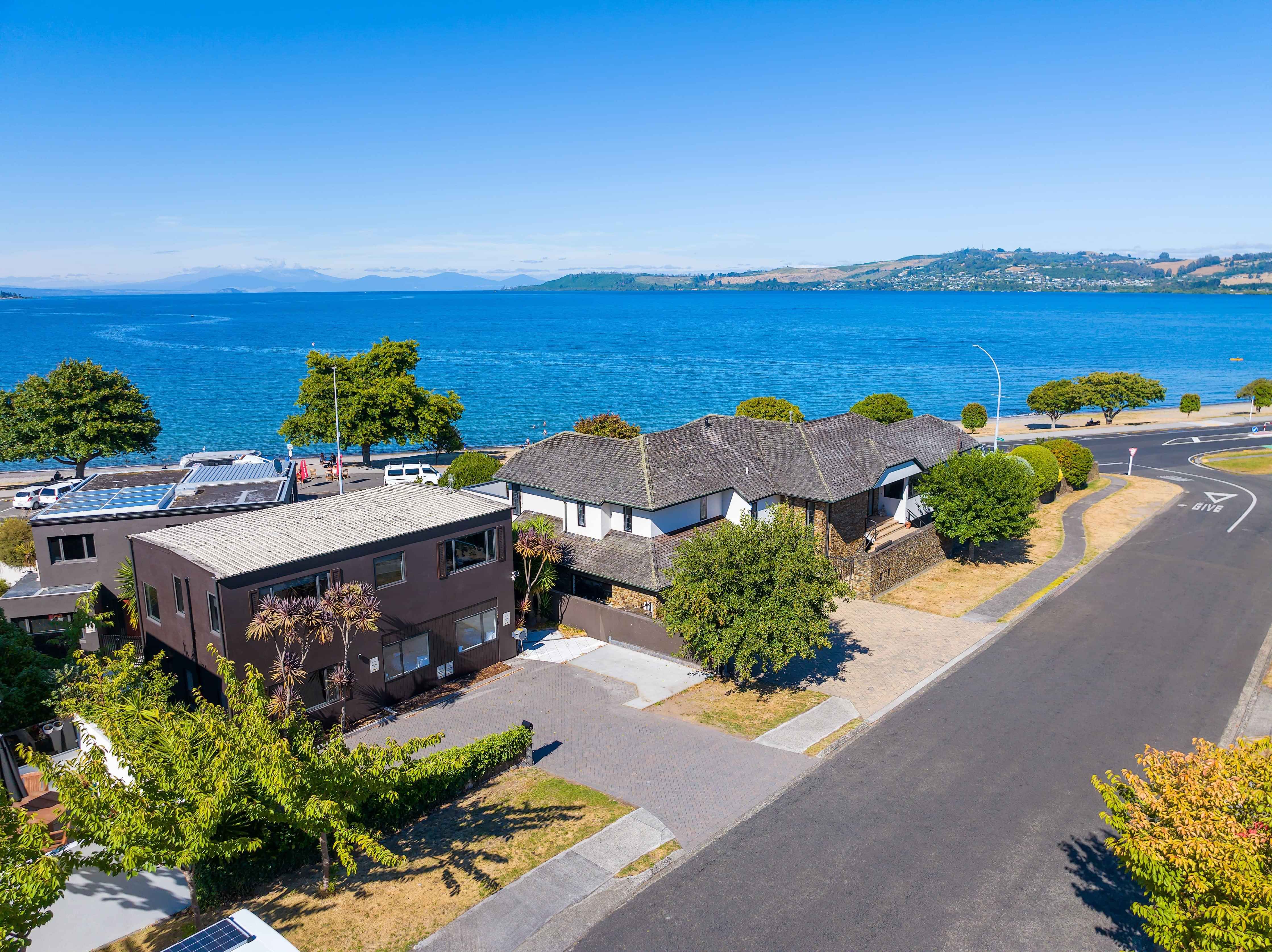 Aerial view of Gather Taupo's exterior and street position with Lake Taupo and surrounding hills in the background