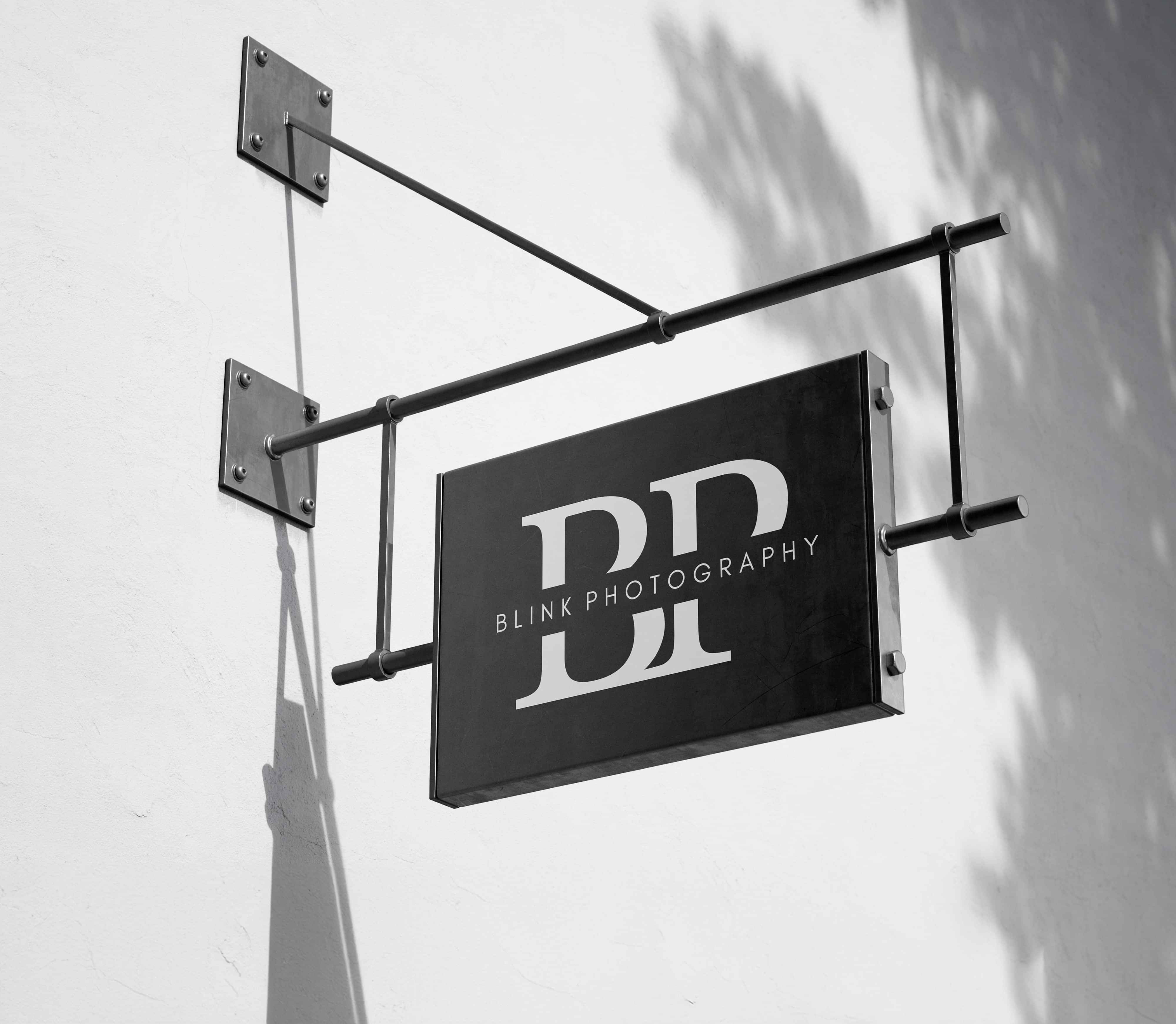 Black and white hanging business sign with 'Blink Photography' logo.