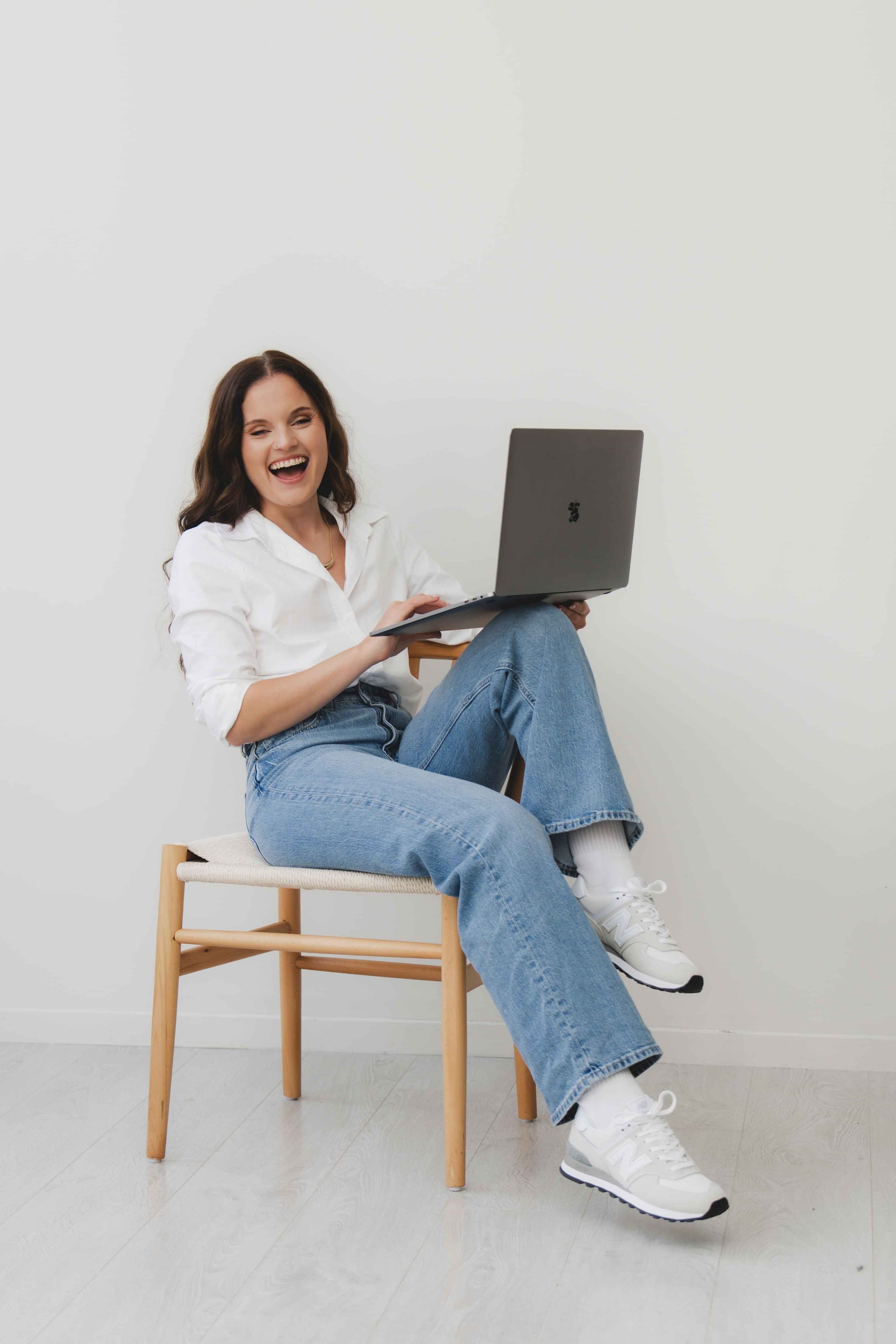 Laykanne working on laptop, sitting on a chair