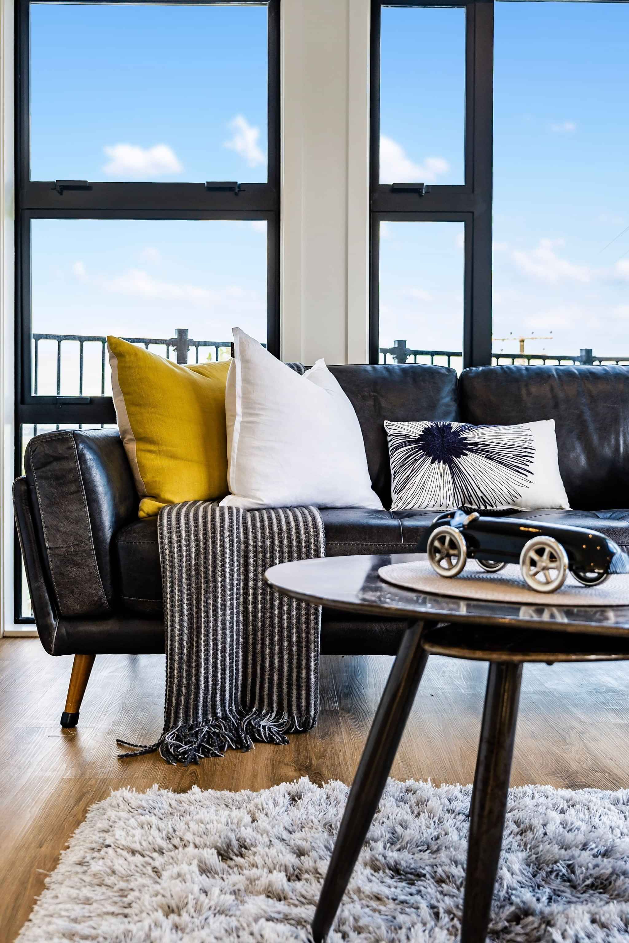 Image of lounge suite with cushions and throw from a recent residential new home build by Auckland builders, Eden Construction. New Zealand.