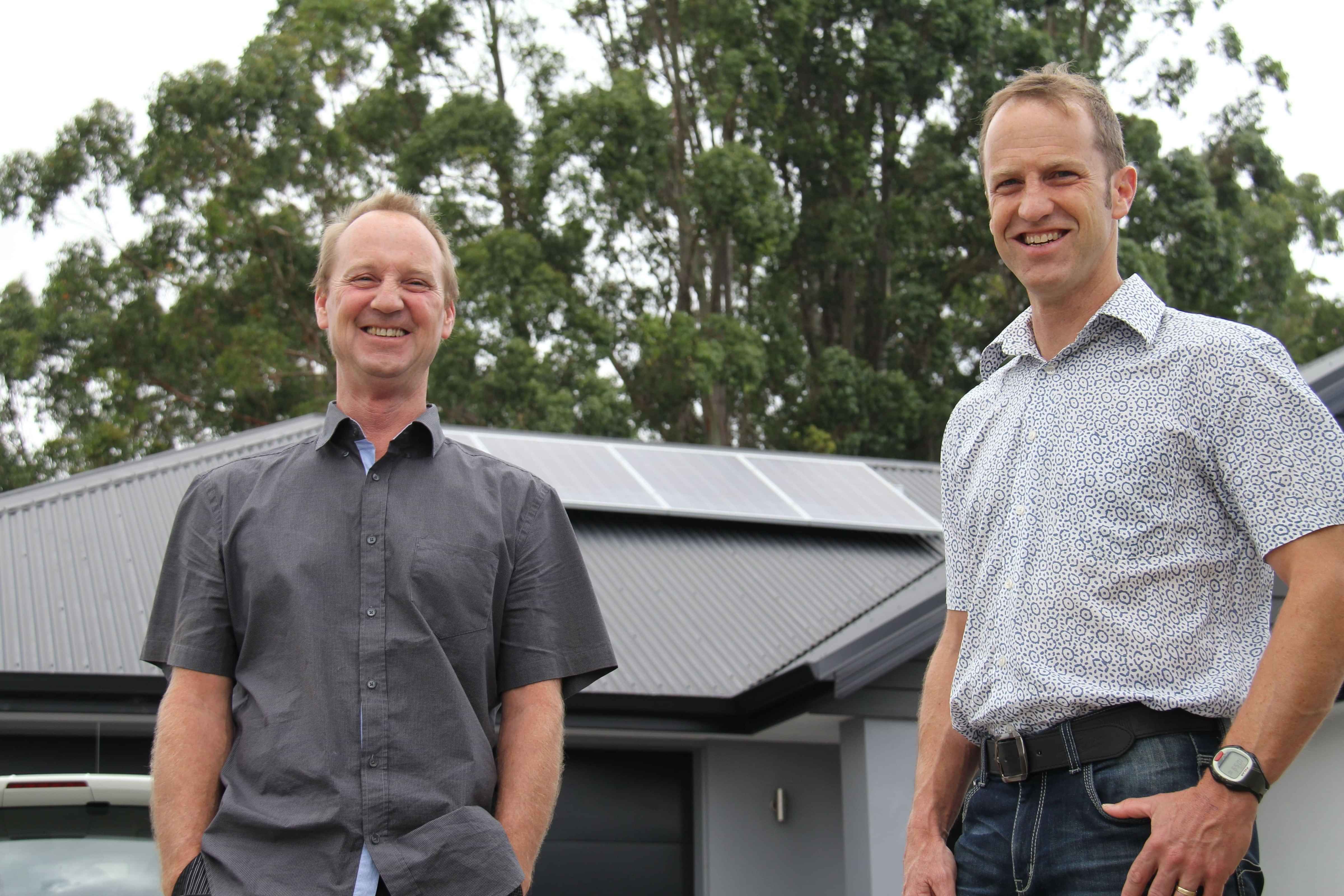 Nik and Phil standing in front of house smiling