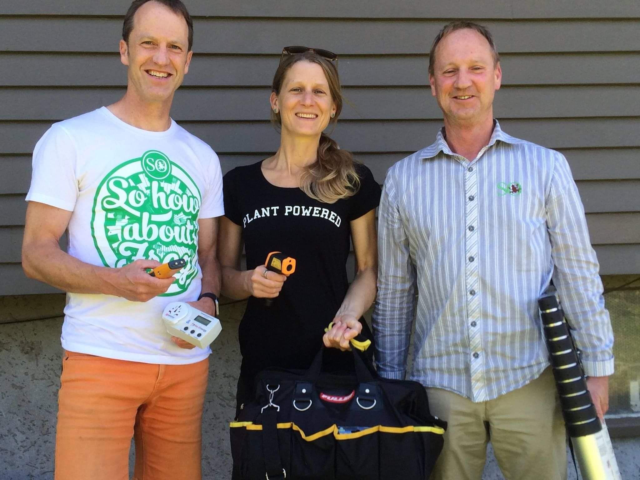 Three people standing together smiling at camera