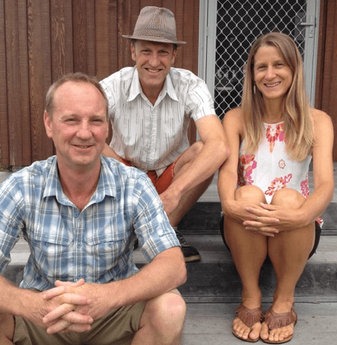 Phil Nil and Jo sitting on steps smiling at camera