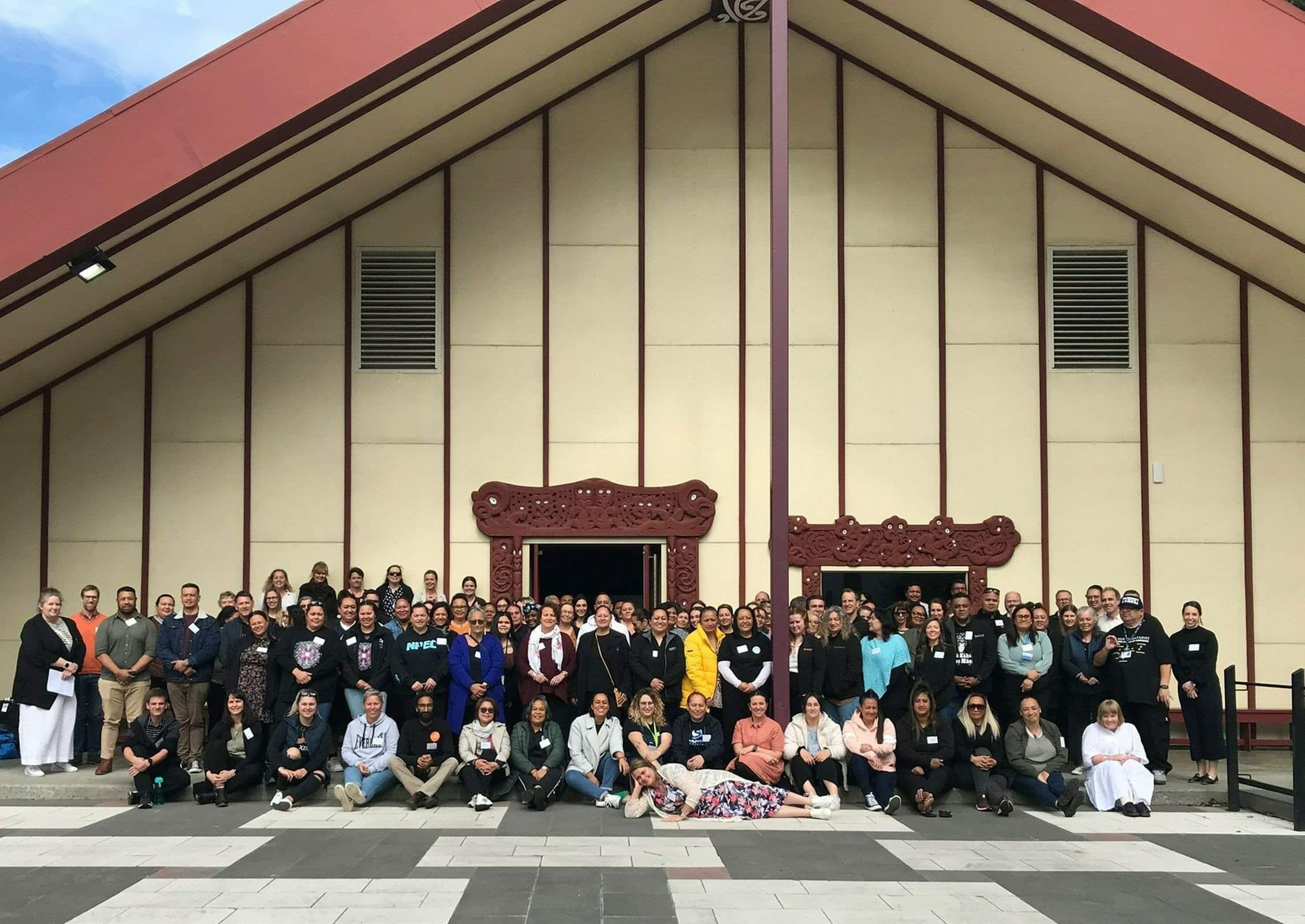 Group of people standing outside marae for photo