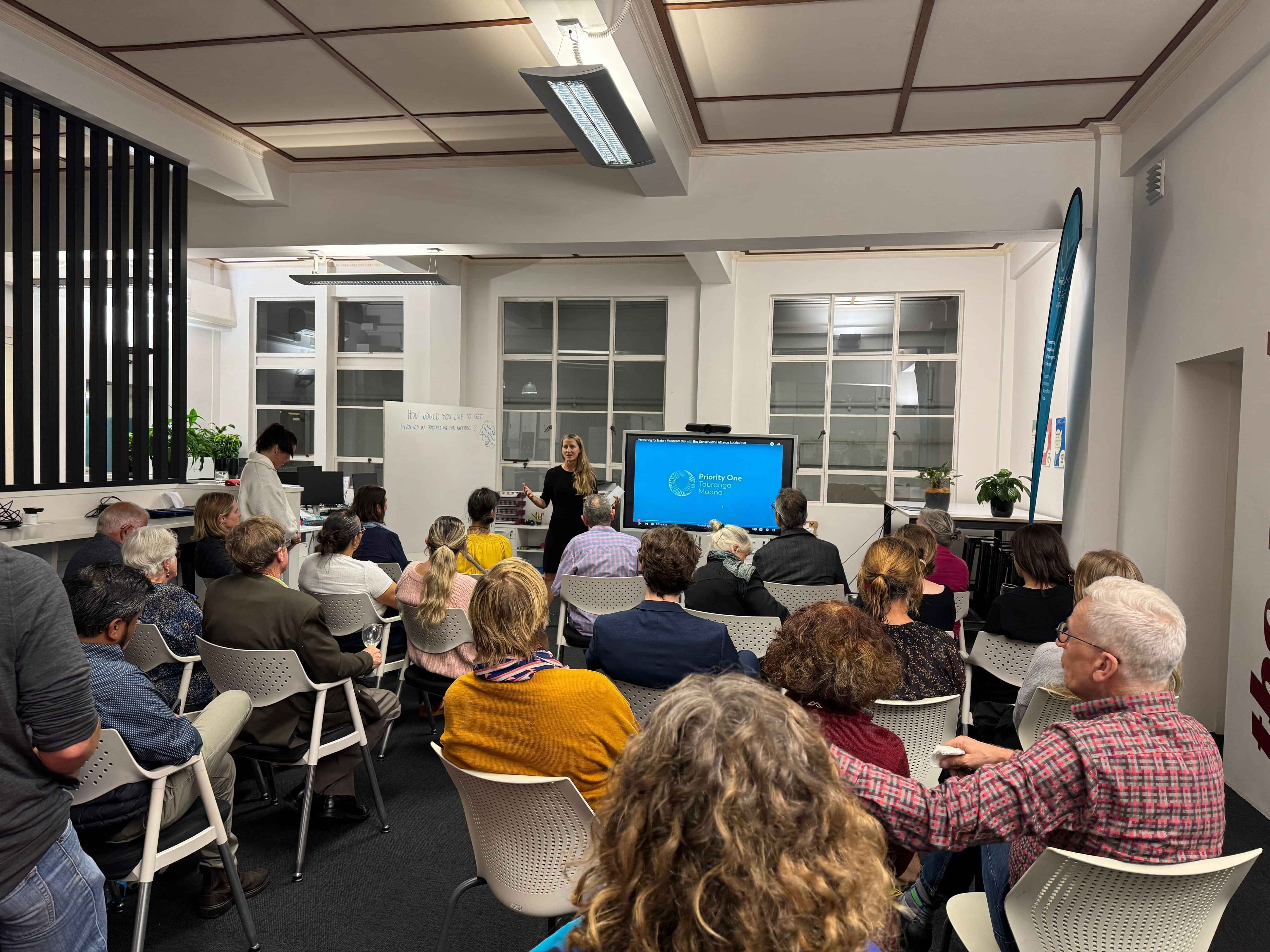 Community members seated and listening during a sustainability workshop or presentation