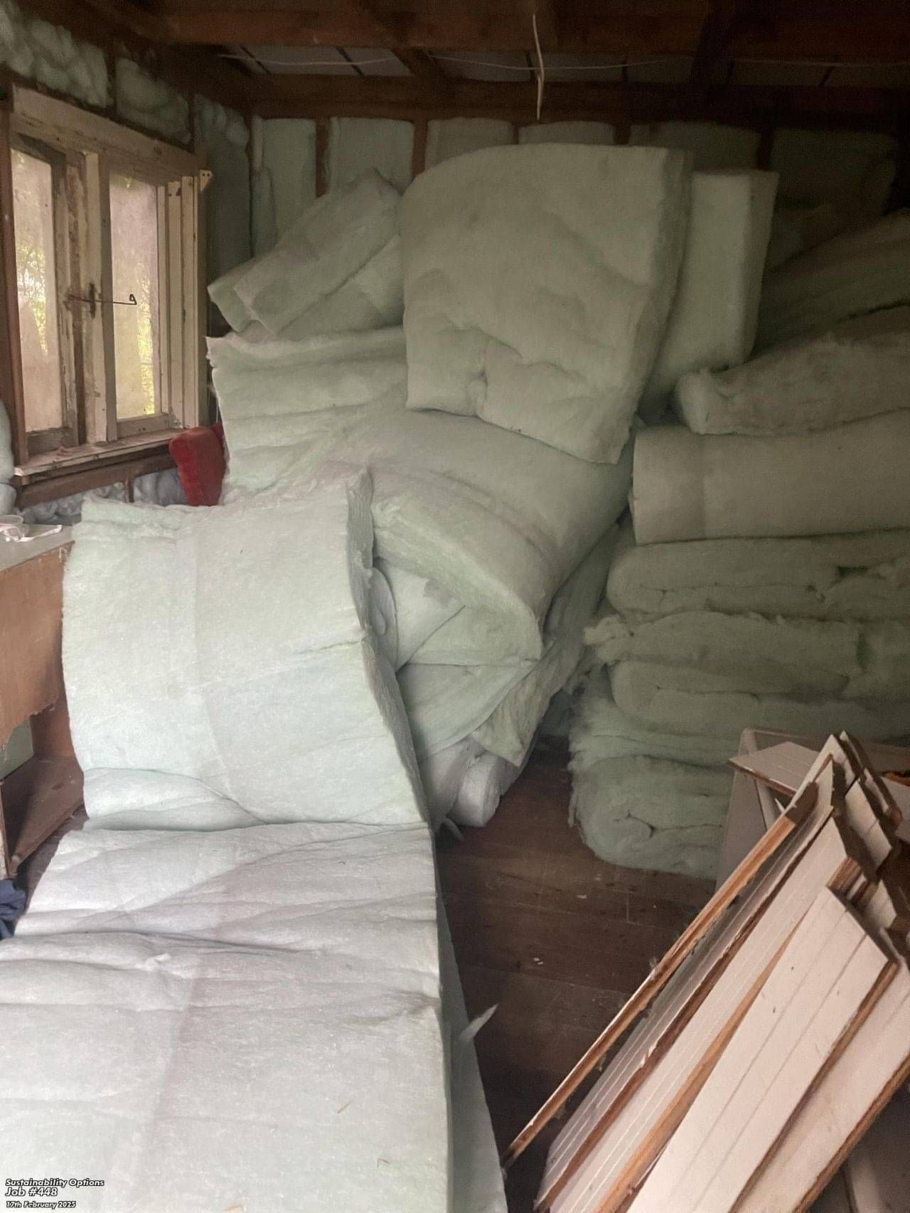 Repurposed insulation material installed within a building wall during a sustainable renovation project