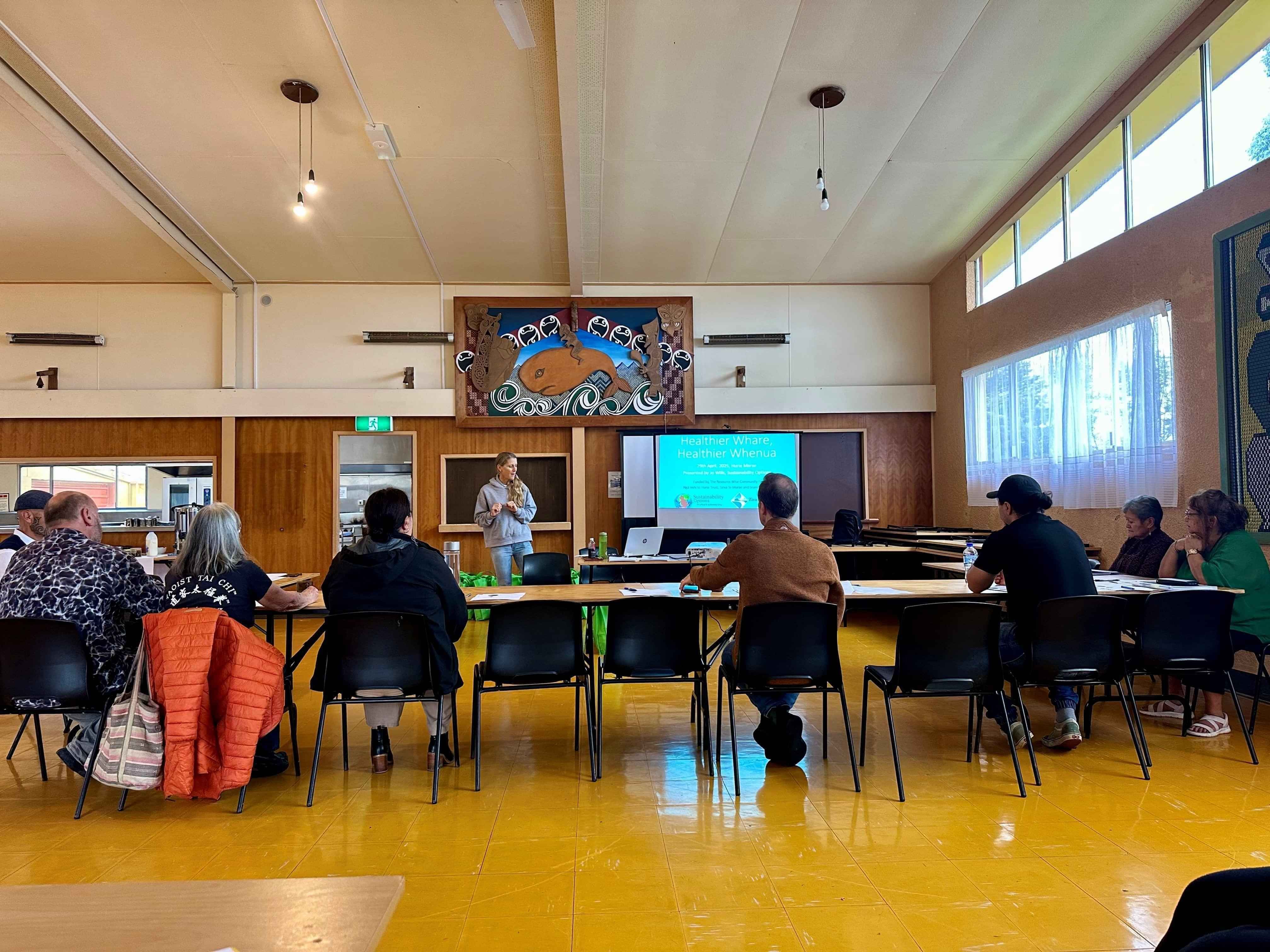 Community members gathered inside a hall participating in a healthy homes and wellbeing workshop