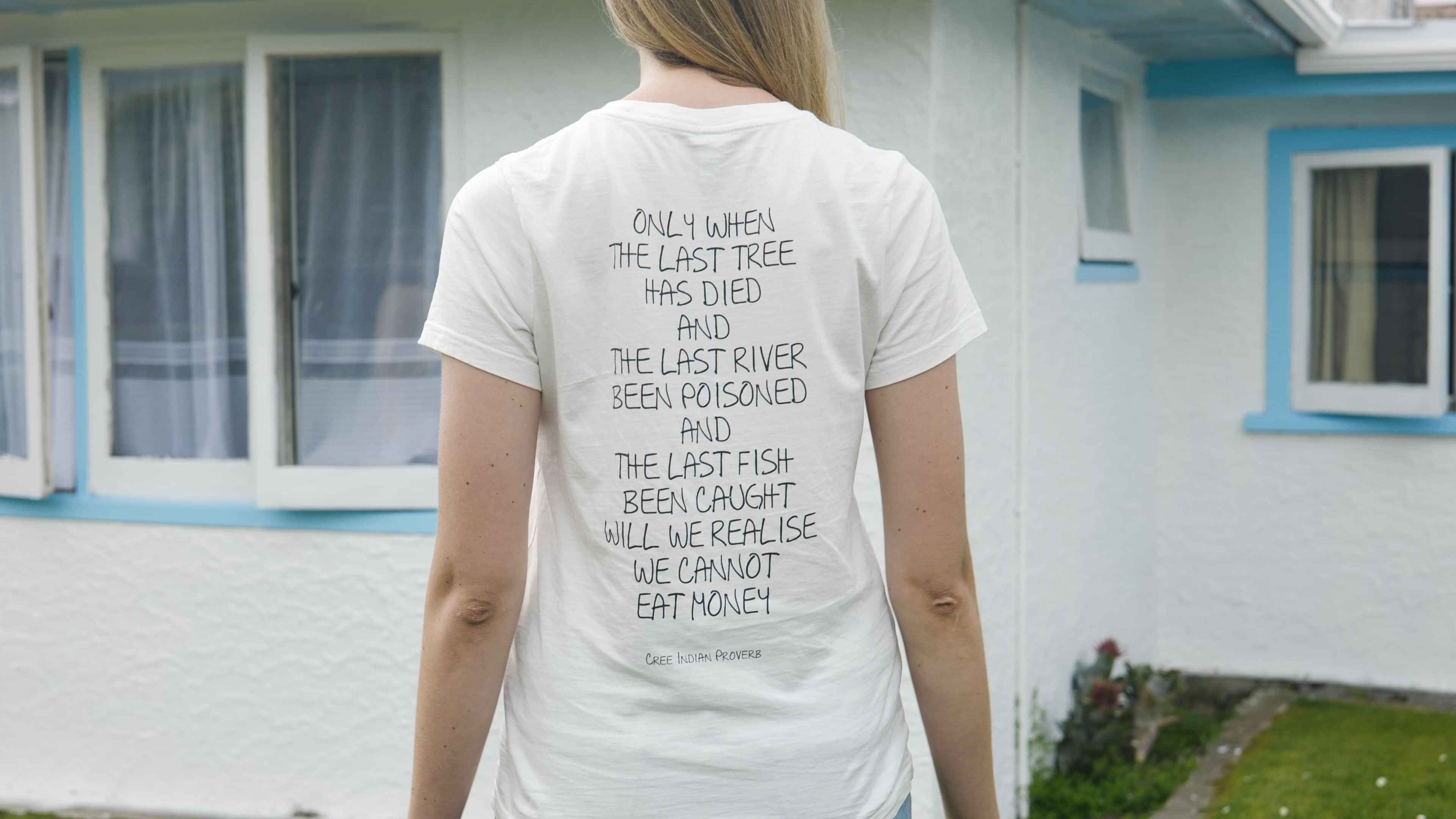 Person wearing a shirt displaying values and purpose statements, standing outdoors