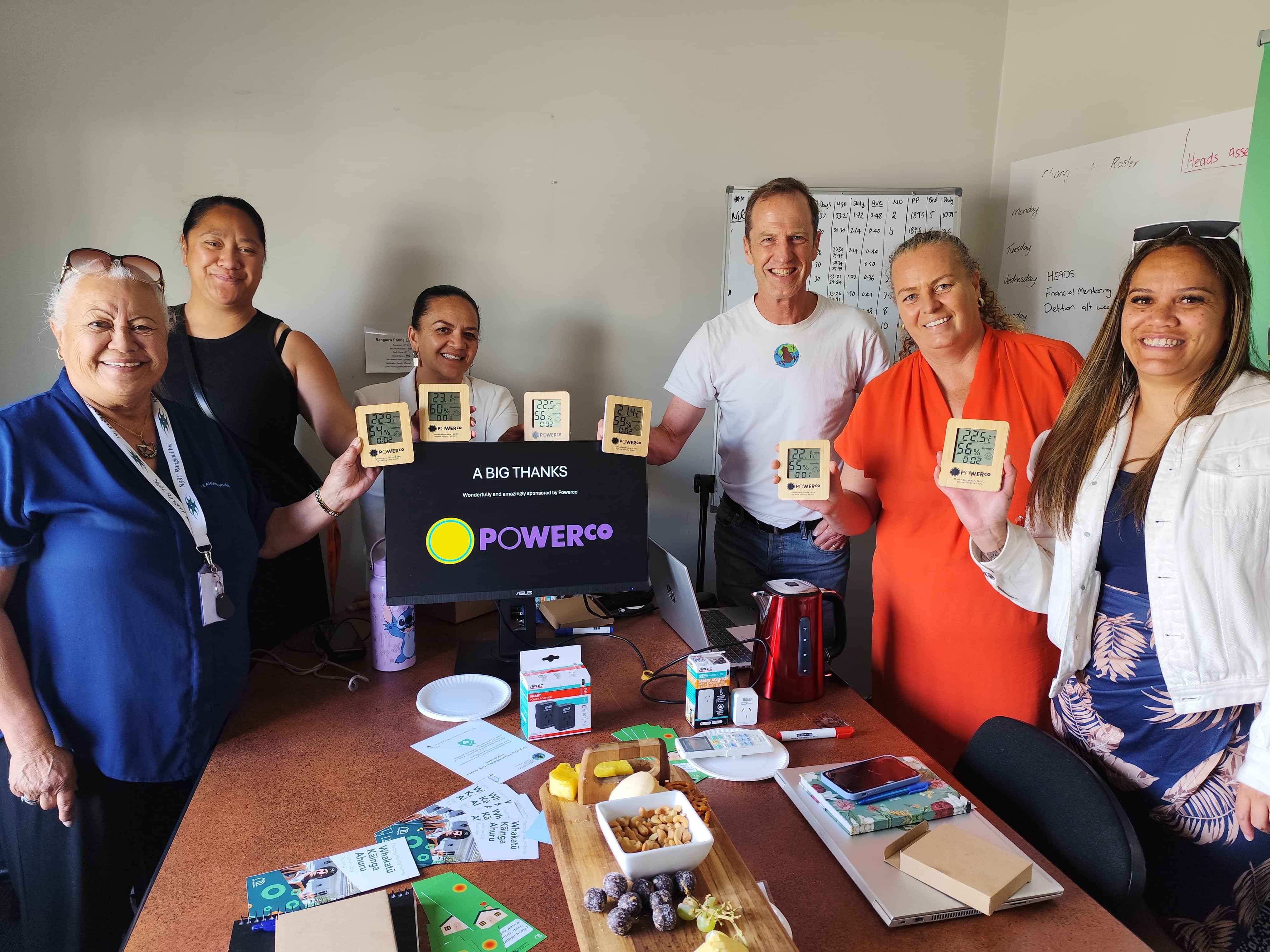 Participants smiling around a table during a community event