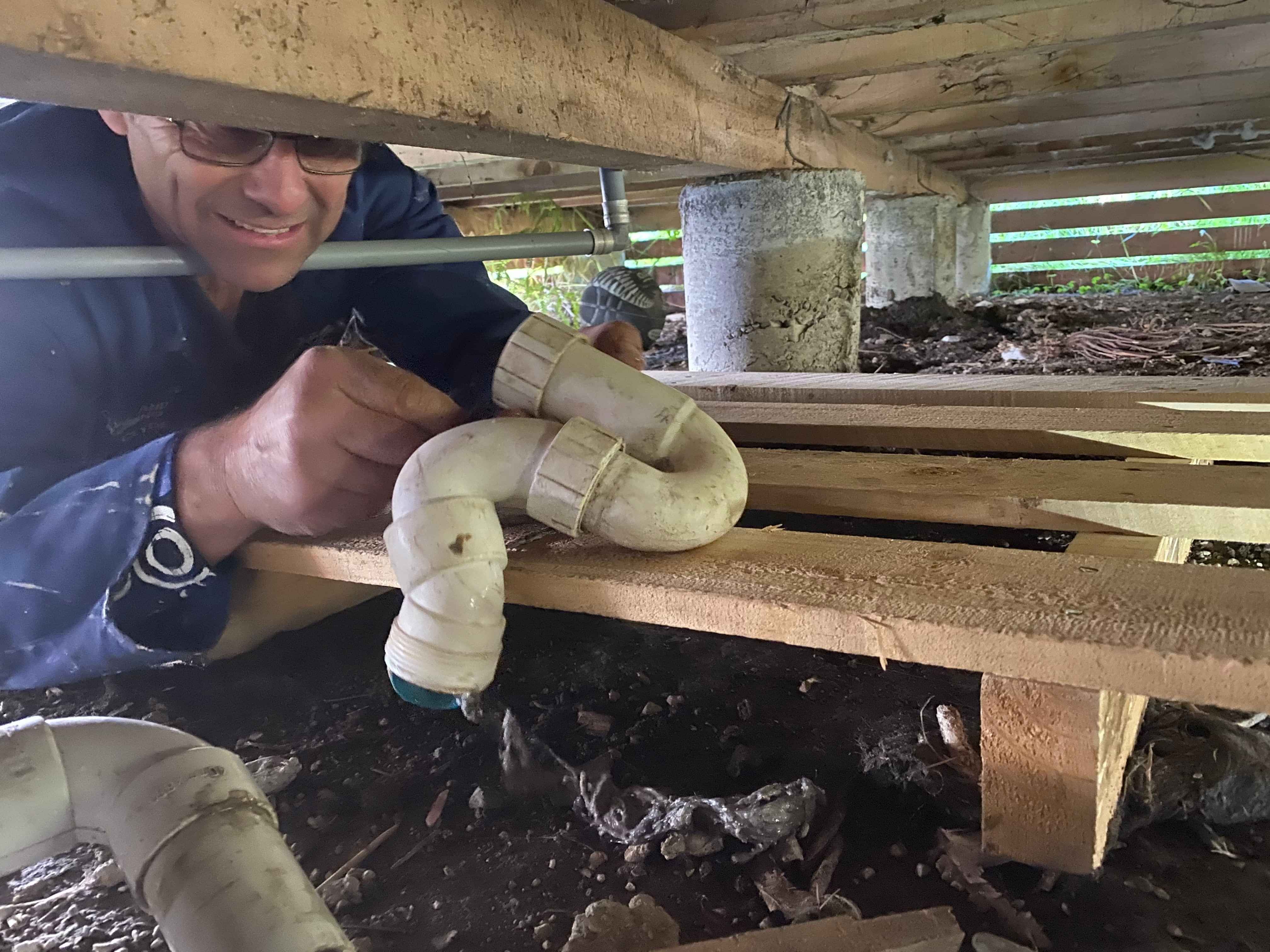 Person working on plumping pipes
