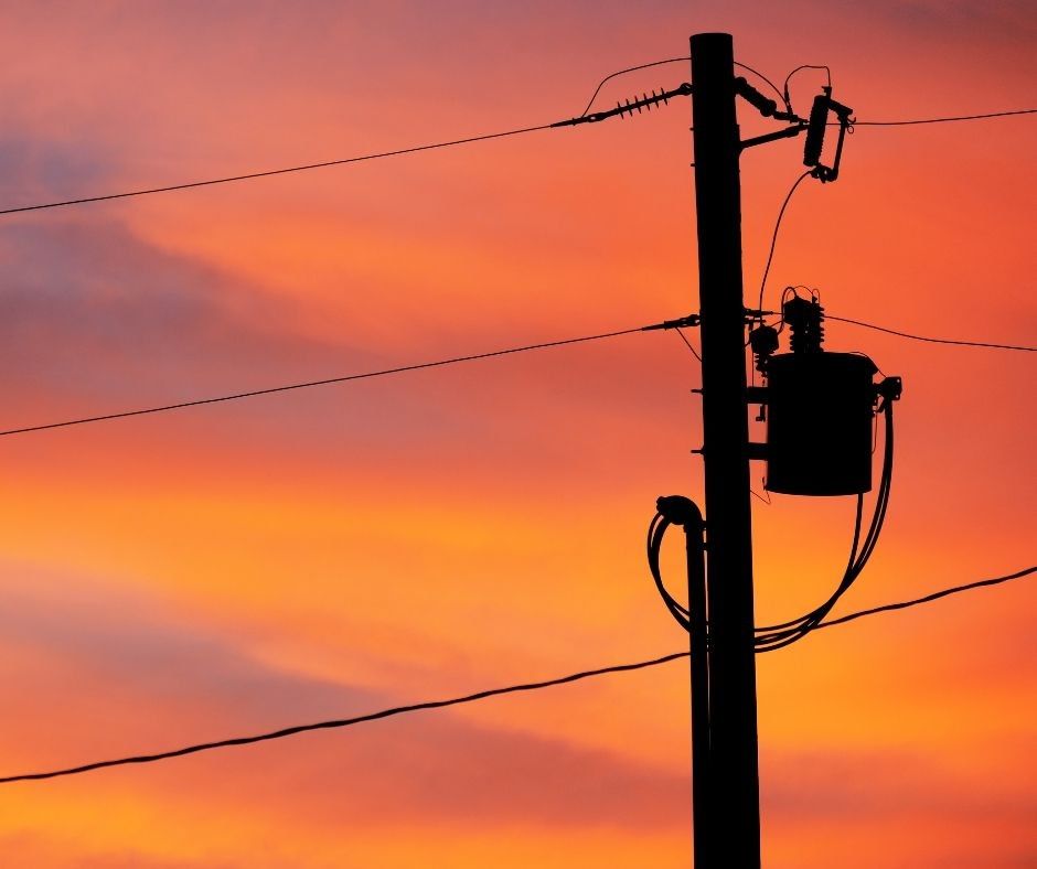 Electricity distribution lines at sunset representing energy infrastructure and future planning