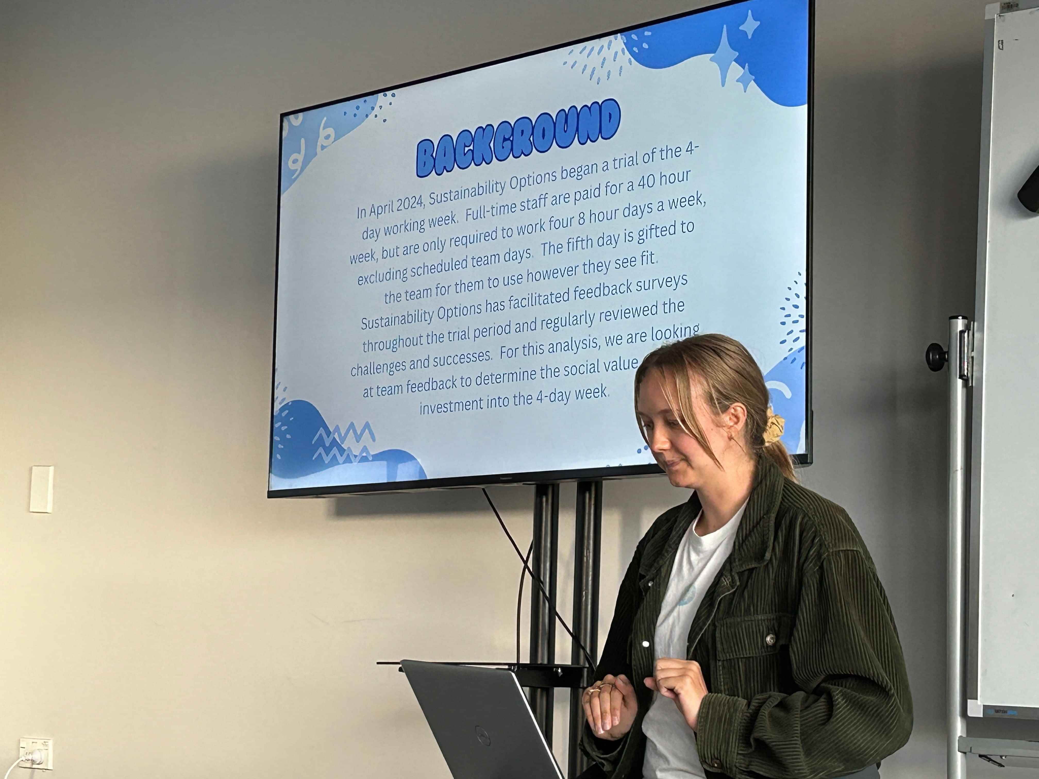 Presenter speaking beside a screen during a workshop or sustainability presentation