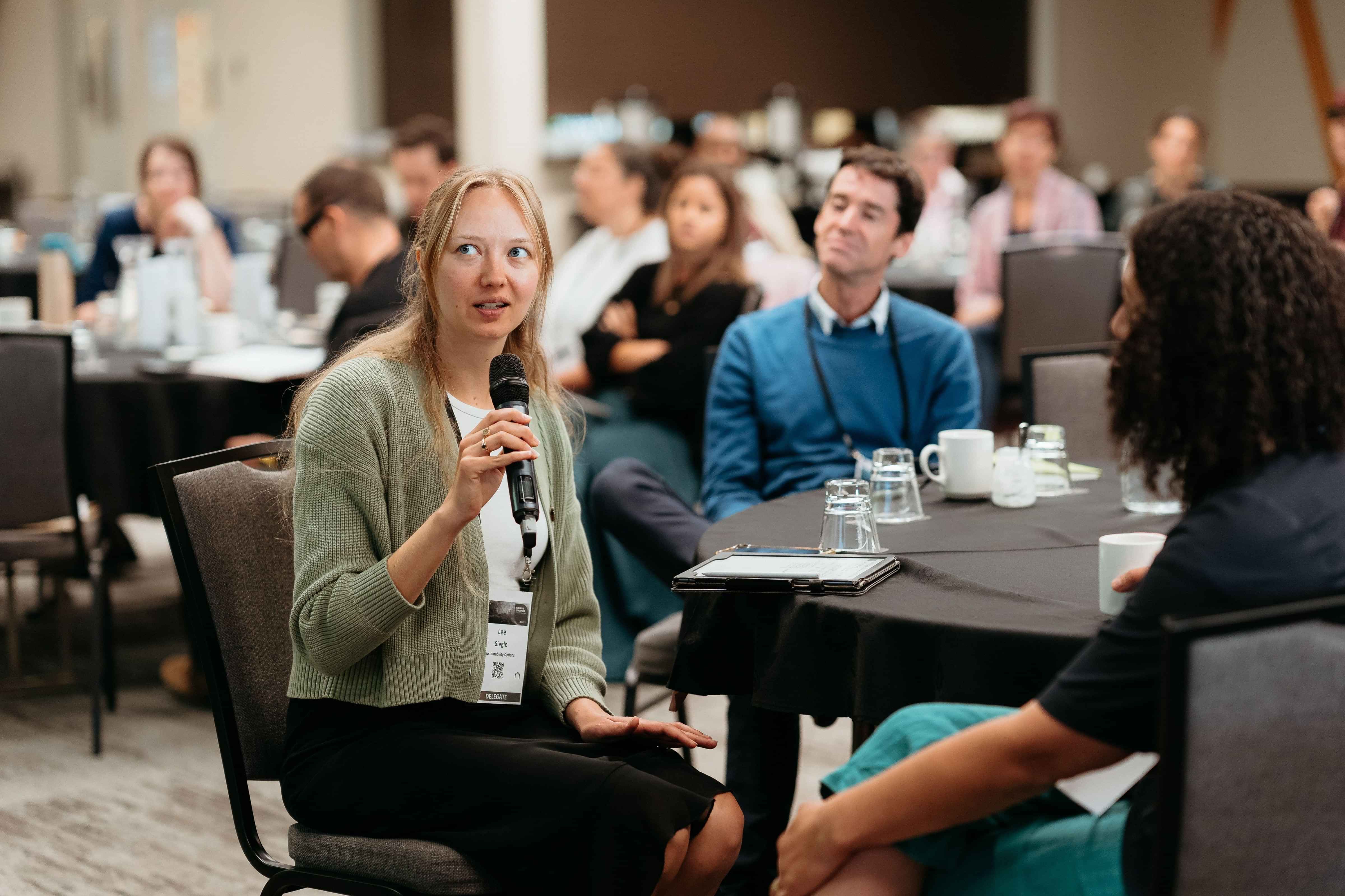 Audience members engaged in discussion during a social impact workshop