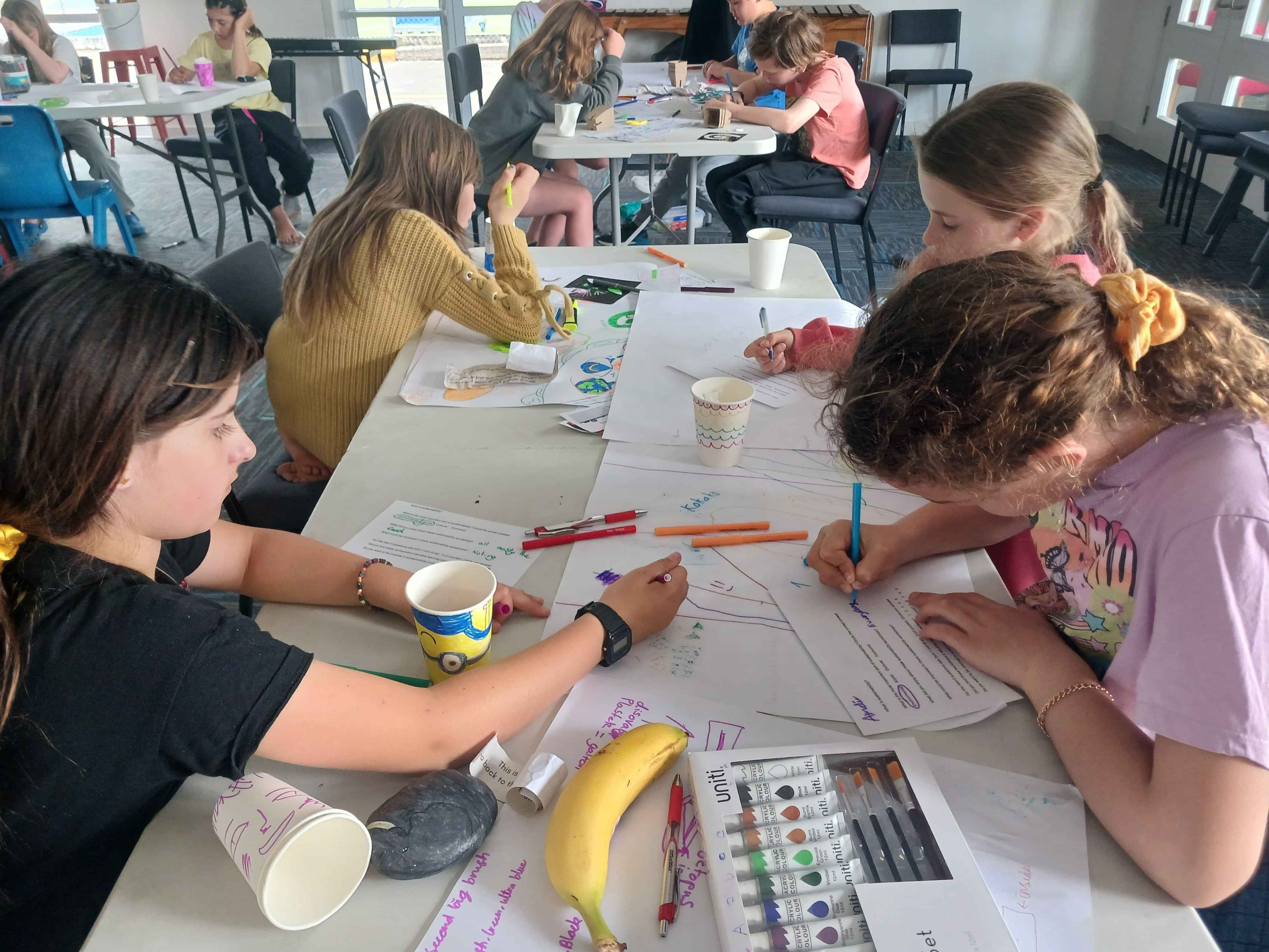 Students creating sustainability-themed artwork and educational projects in a classroom