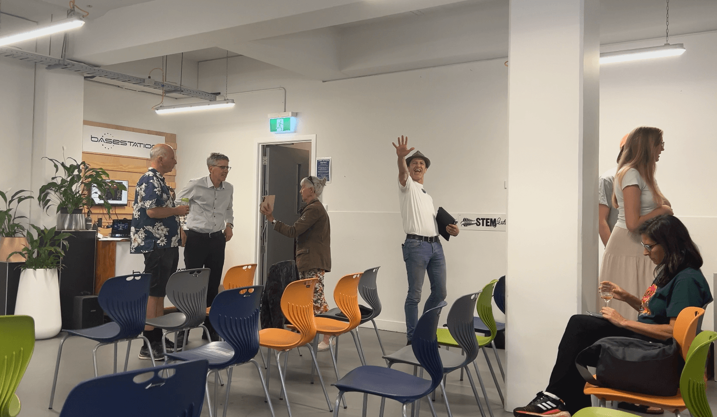 Group of people in room, man waving