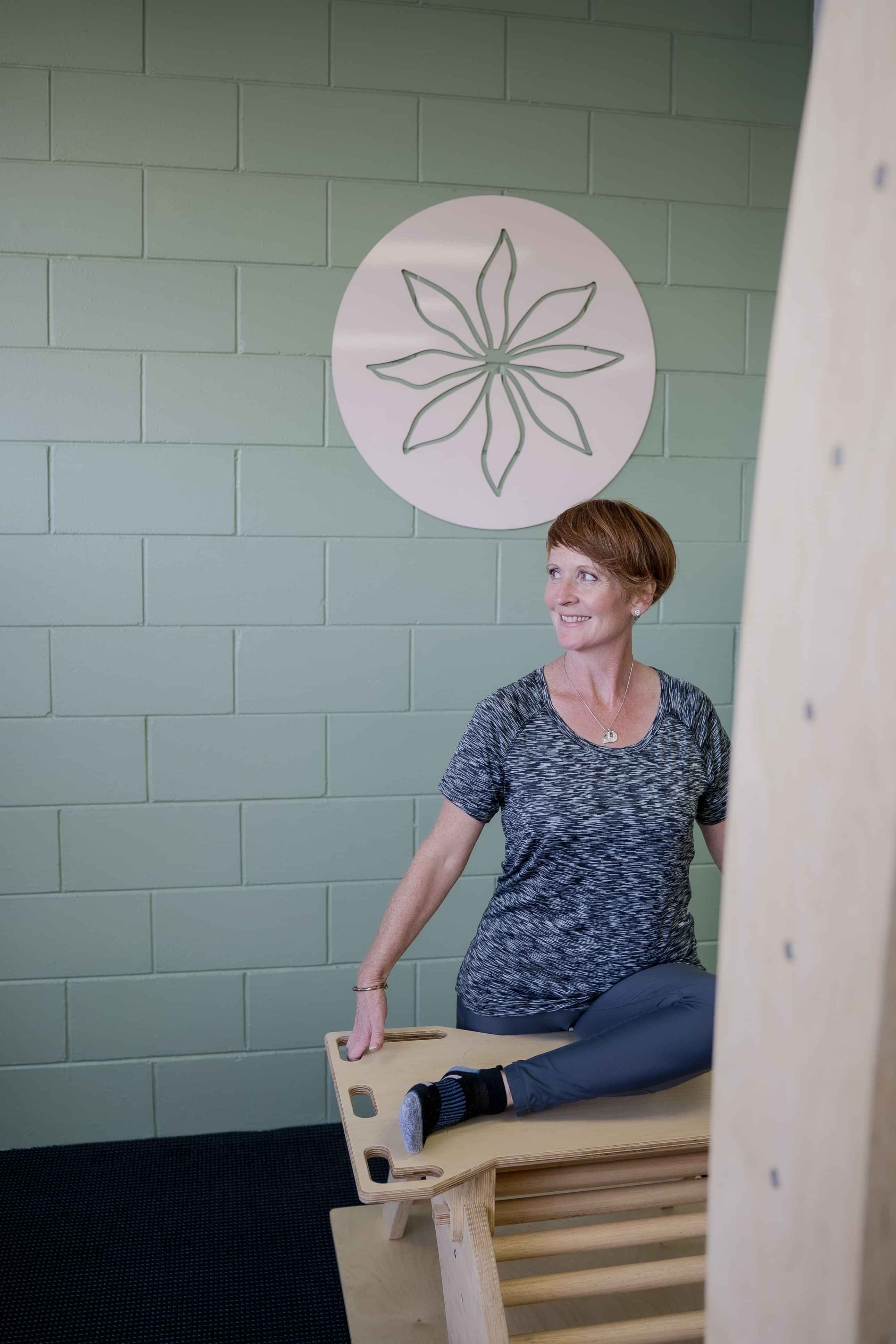 Image of smiling woman on stretching machine at Self, wellness studio in Alexandra.
