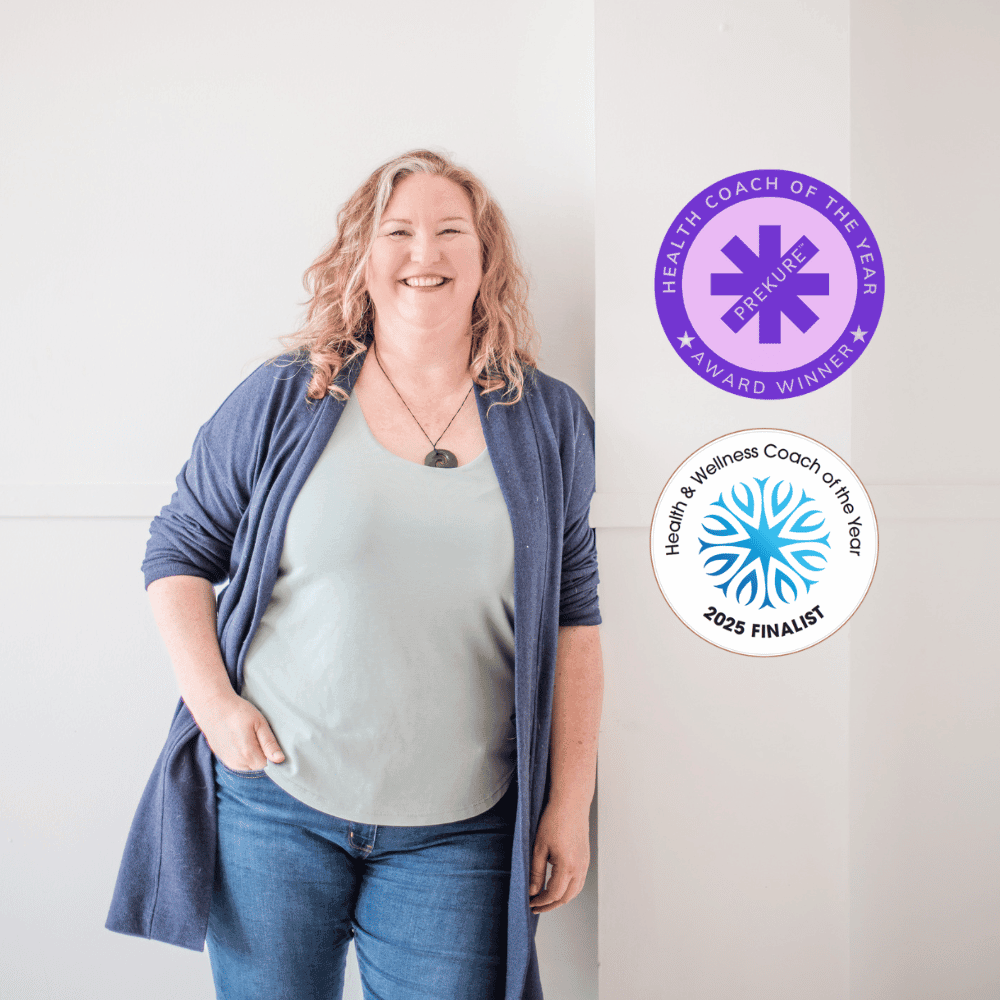 Photo of holistic health coaching expert, Elizabeth Marshall, leaning against a wall smiling at the camera.  