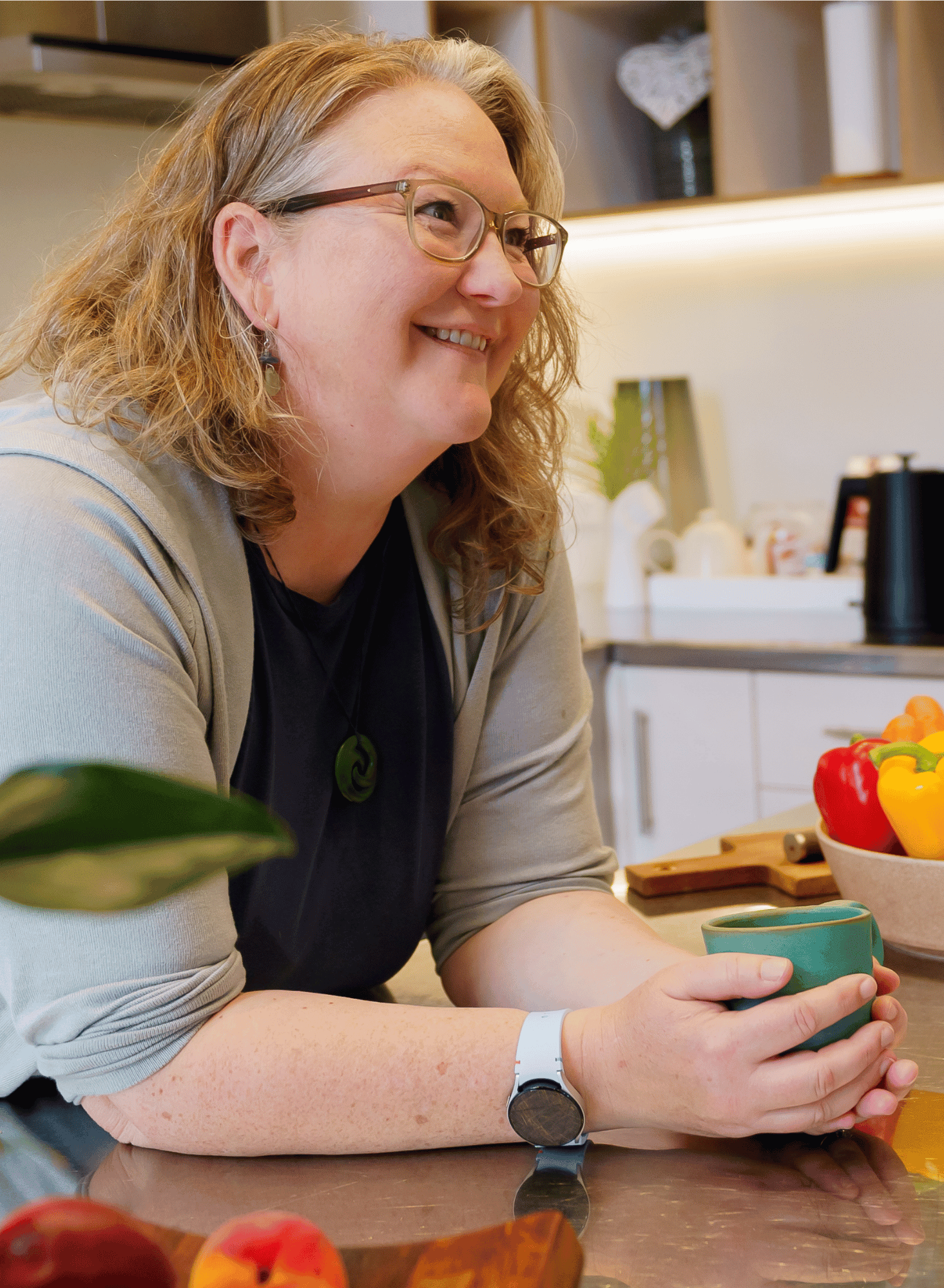 Photo of Elizabeth in the kitchen nutrition coaching and looking at someone beyond the camera.