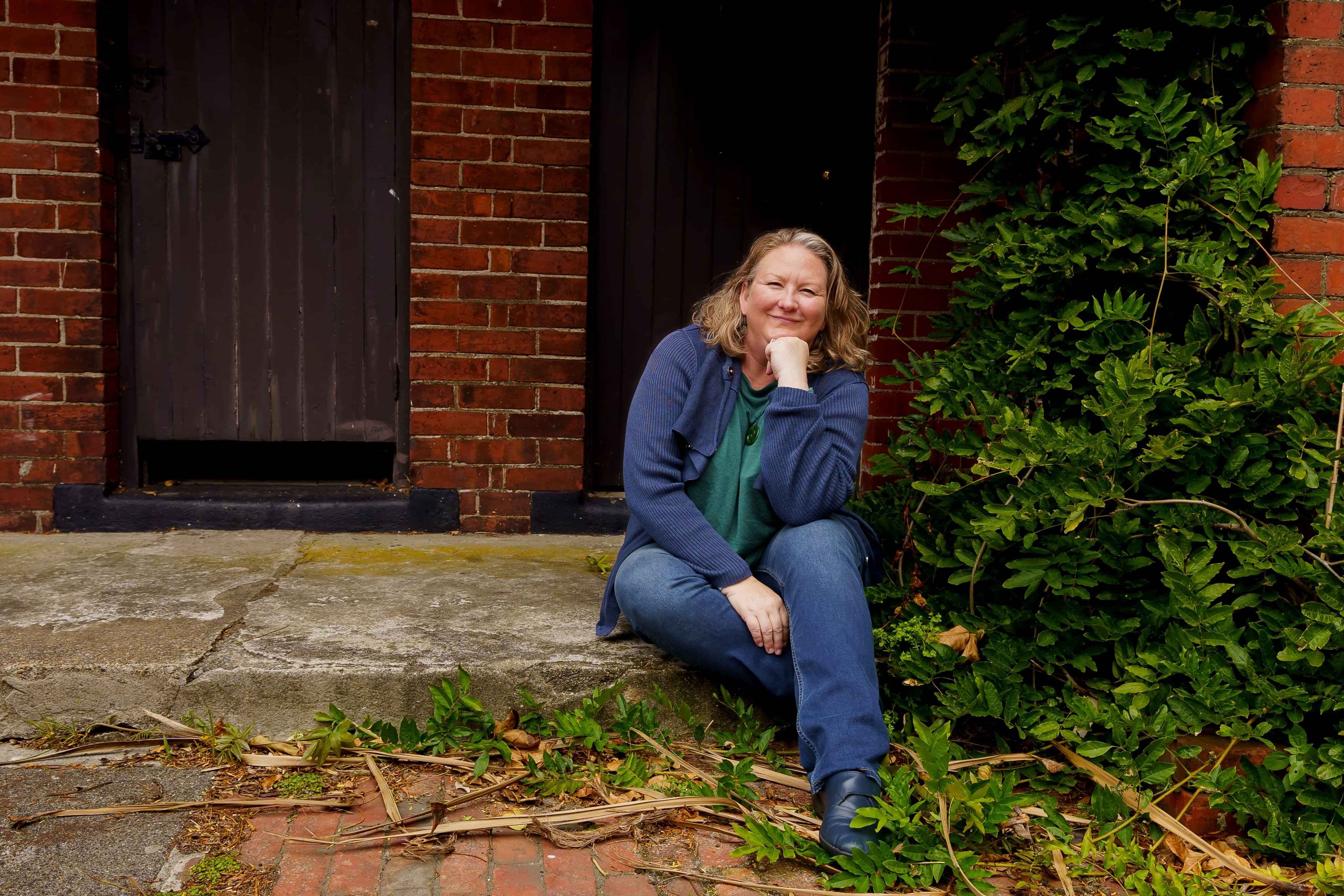 Photo of Elizabeth sitting outside a red brick building