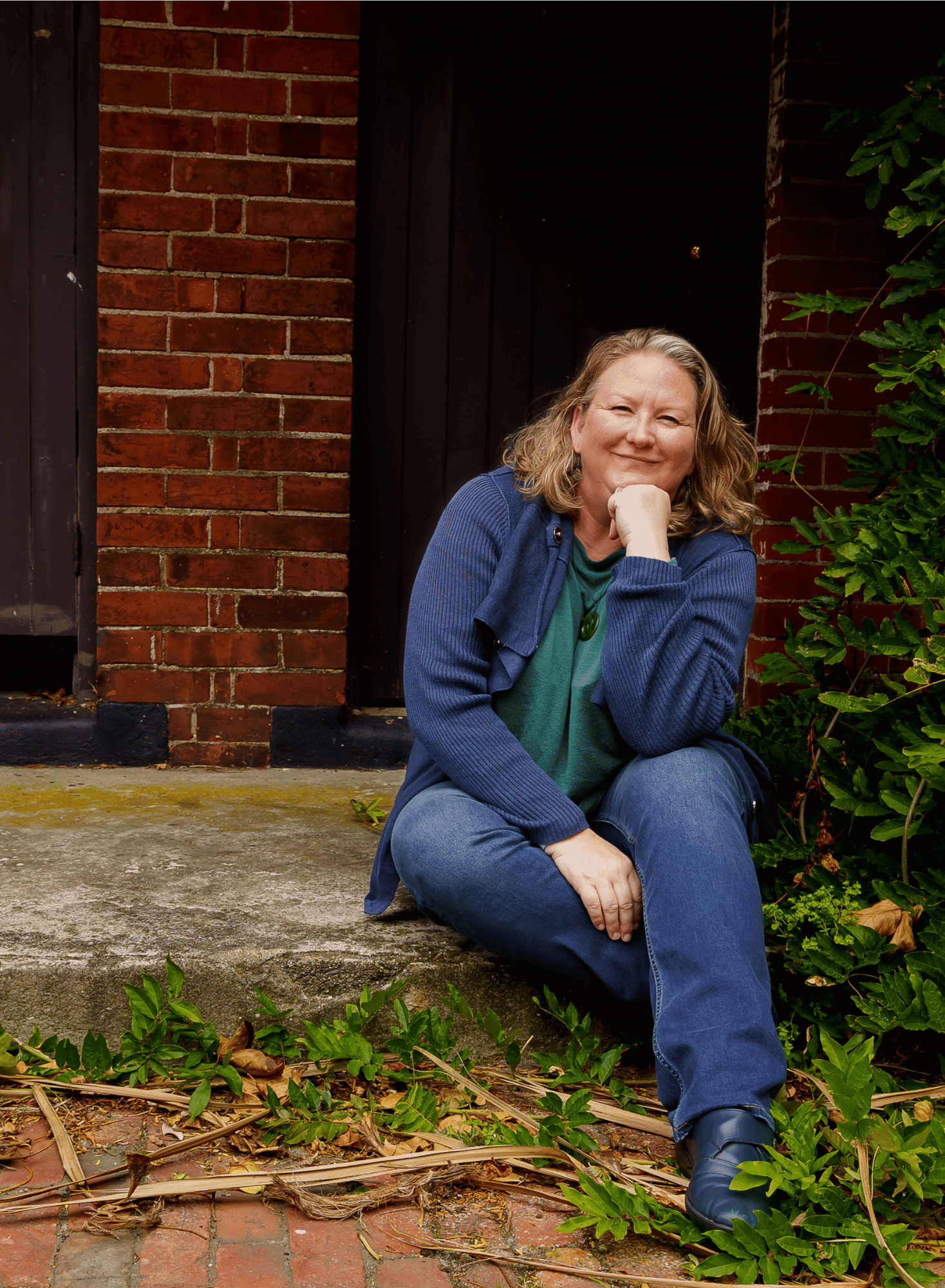 Photo of Elizabeth sitting outside a red brick building