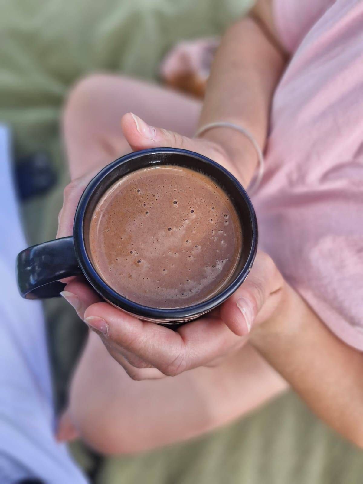 Picture of a mug of cacao being held taken at the Enspirited Wellness Retreat by Ashlee Sturme.