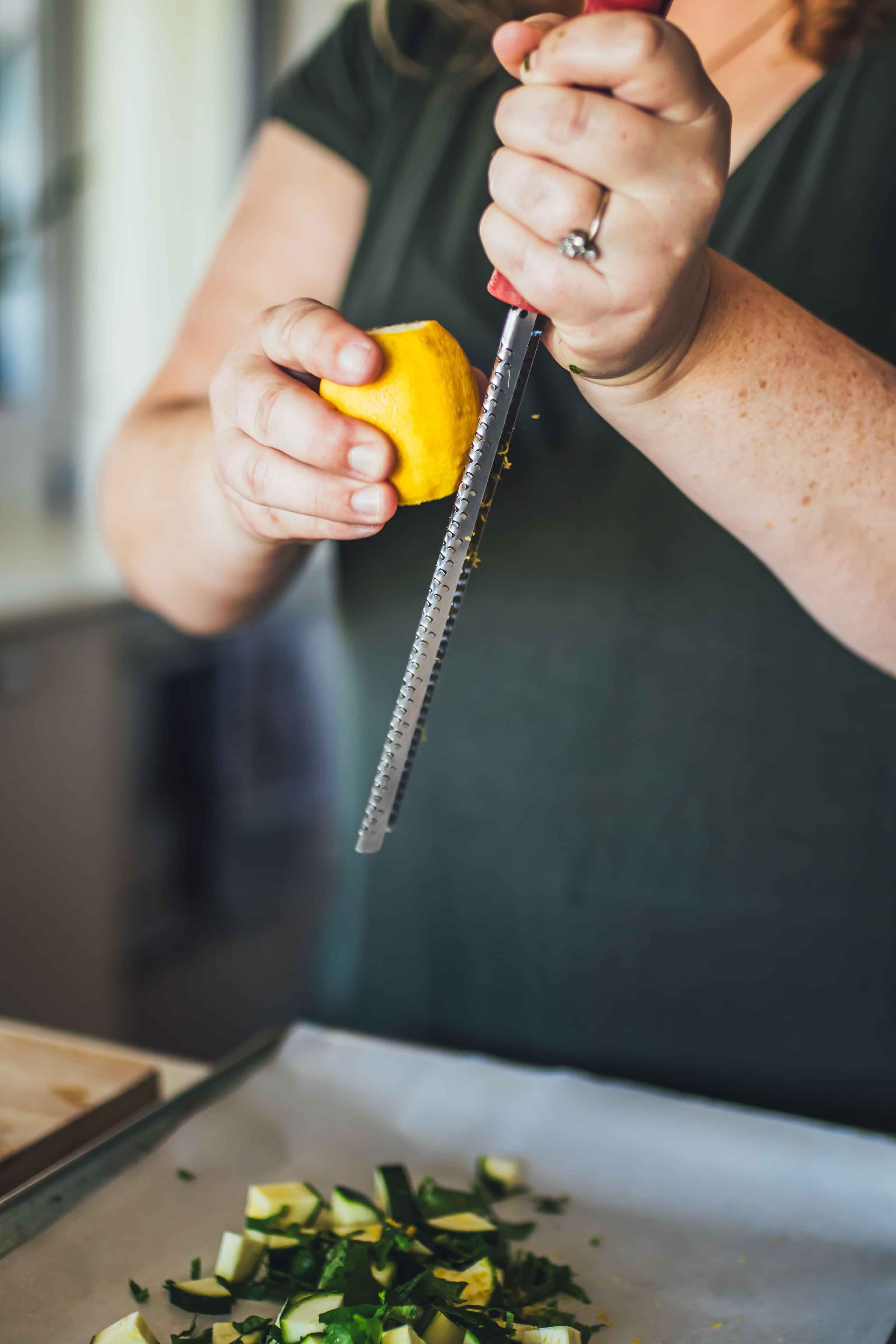 Photo of Elizabeth's, holistic health nutrition coach, grating a lemon in a kitchen.