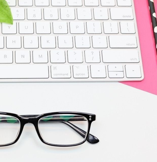 Flat lay of computer keyboard and glasses on a desk – representing organised executive and business admin support services.