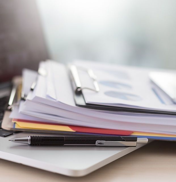Stack of folders and documents with a pen – symbolising professional Xero bookkeeping and accounting support for small businesses.